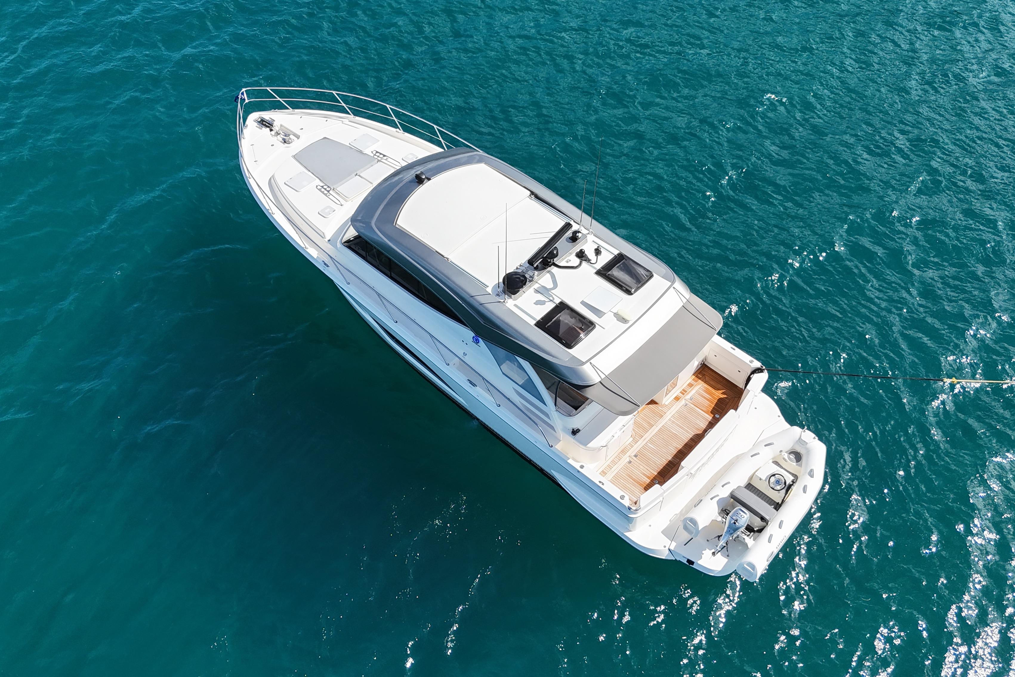 Aerial view of 2023 Riviera 465 SUV yacht on clear blue water.