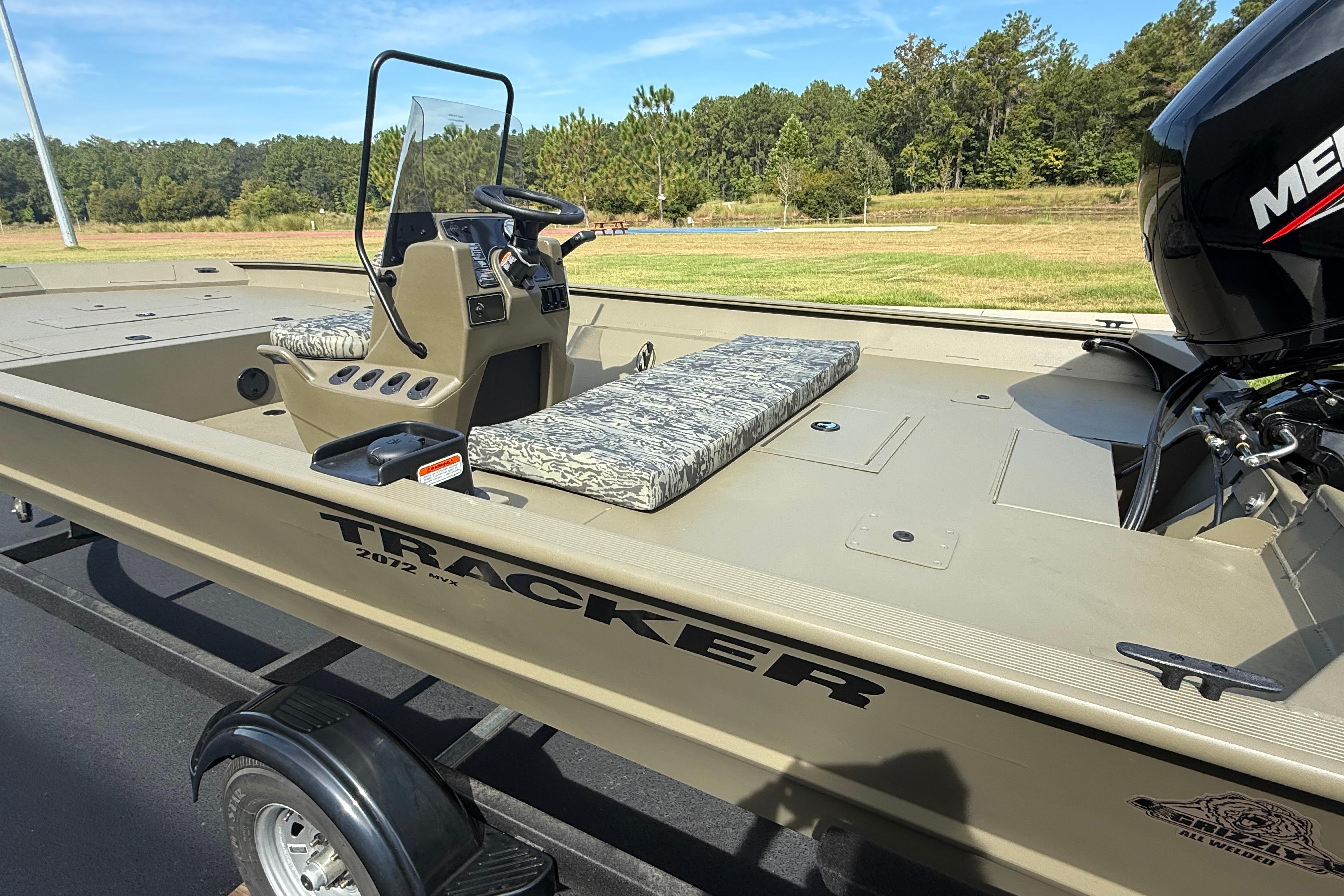 2026 Tracker Grizzly 2072 CC boat on trailer, parked outdoors.