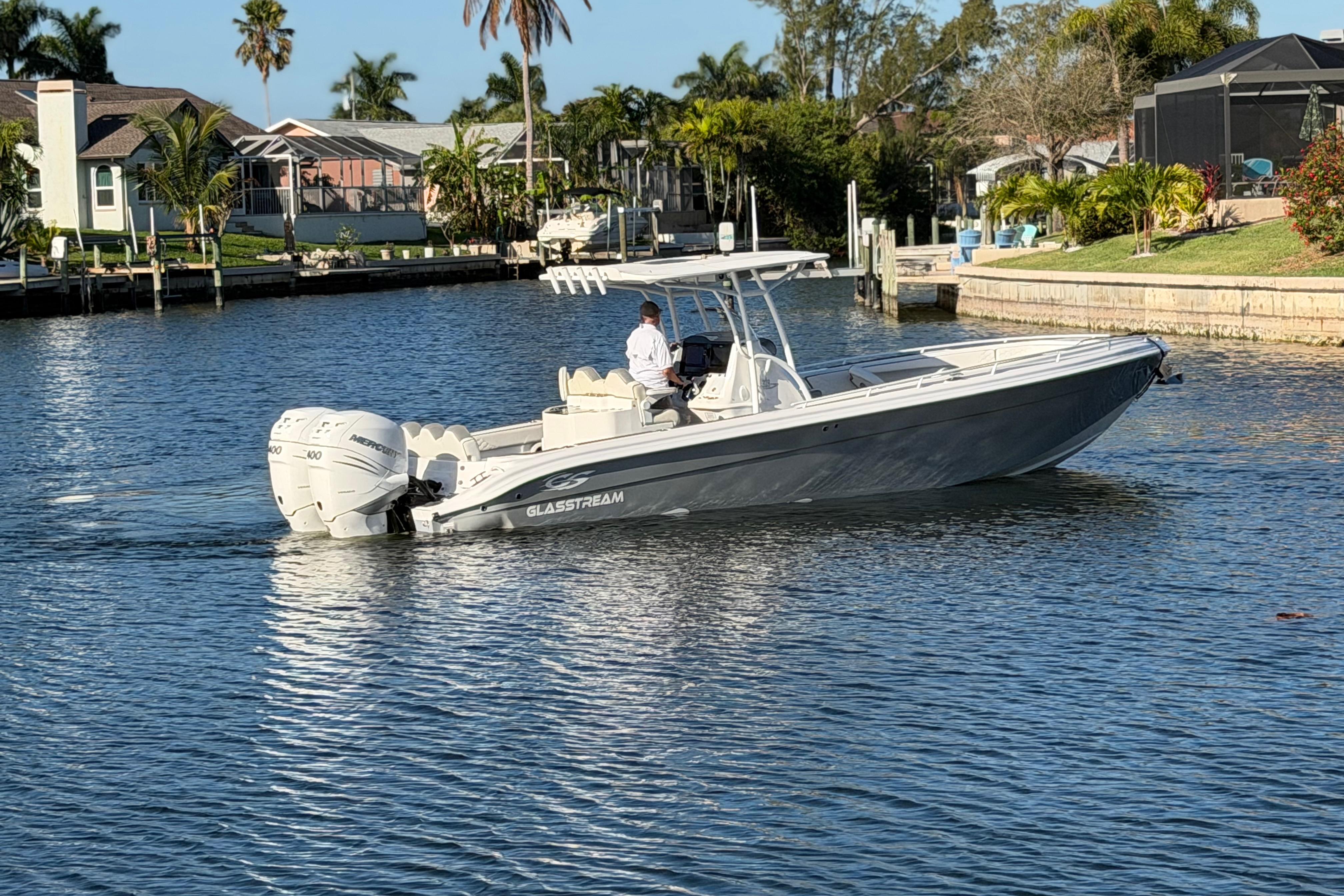 2022 Glasstream 328 Pro-XS boat cruising on a sunny waterfront.