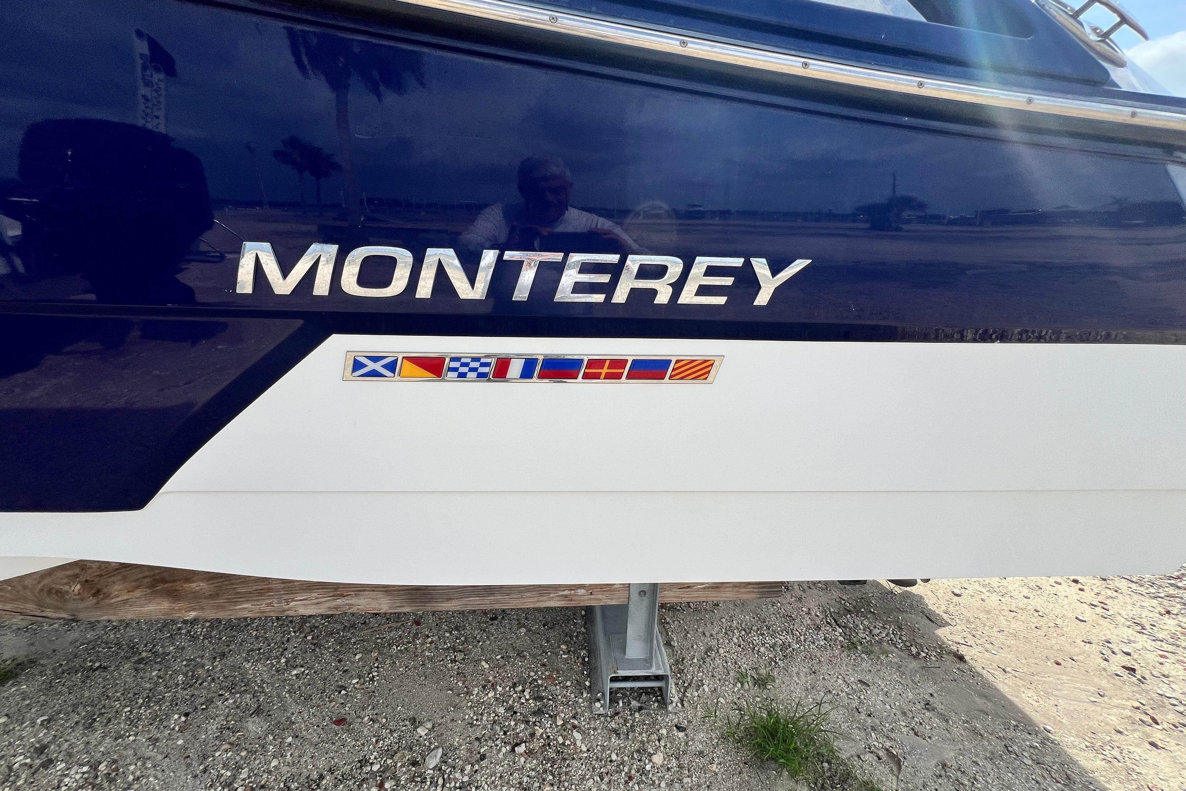 2015 Monterey 268SS Super Sport boat with nautical flags on the hull.