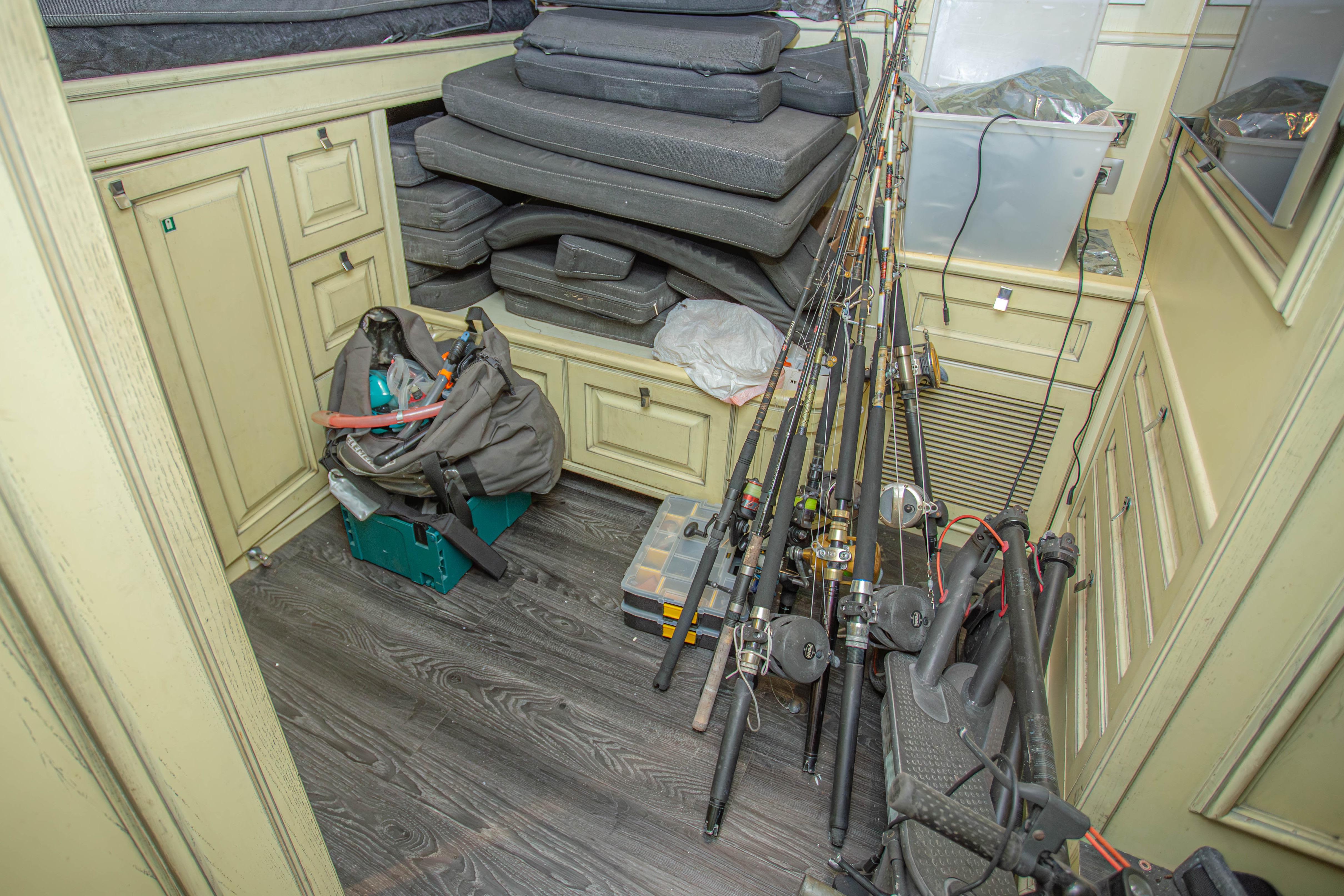 Storage area on 2014 Fifth Ocean Yachts Explorer, featuring fishing rods and equipment.