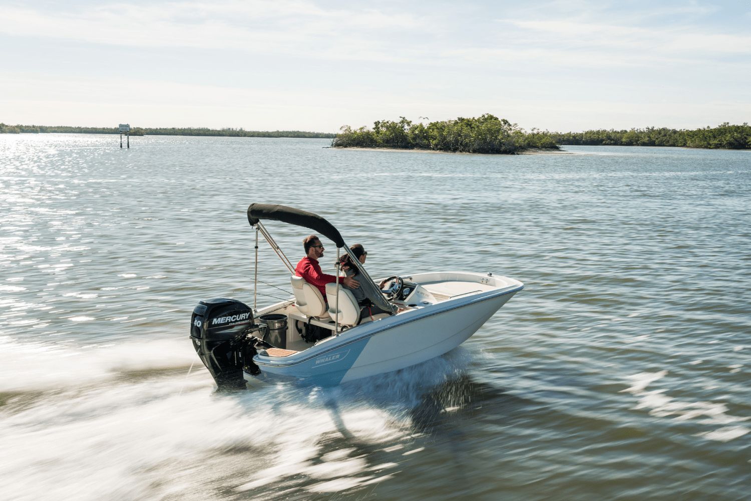 A 2026 Boston Whaler 130 Super Sport on calm water with two people aboard.