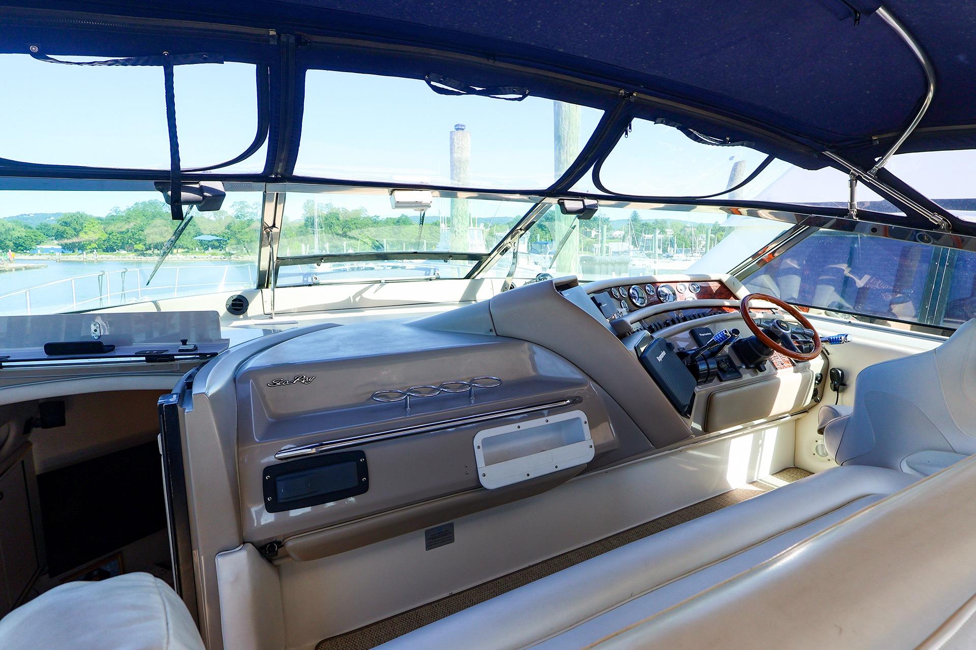 Interior view of a 1998 Sea Ray 500 Sundancer yacht cockpit with steering wheel and controls.