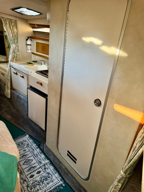 Interior of a 1992 Sea Ray 290 Sundancer featuring a kitchenette and carpet.