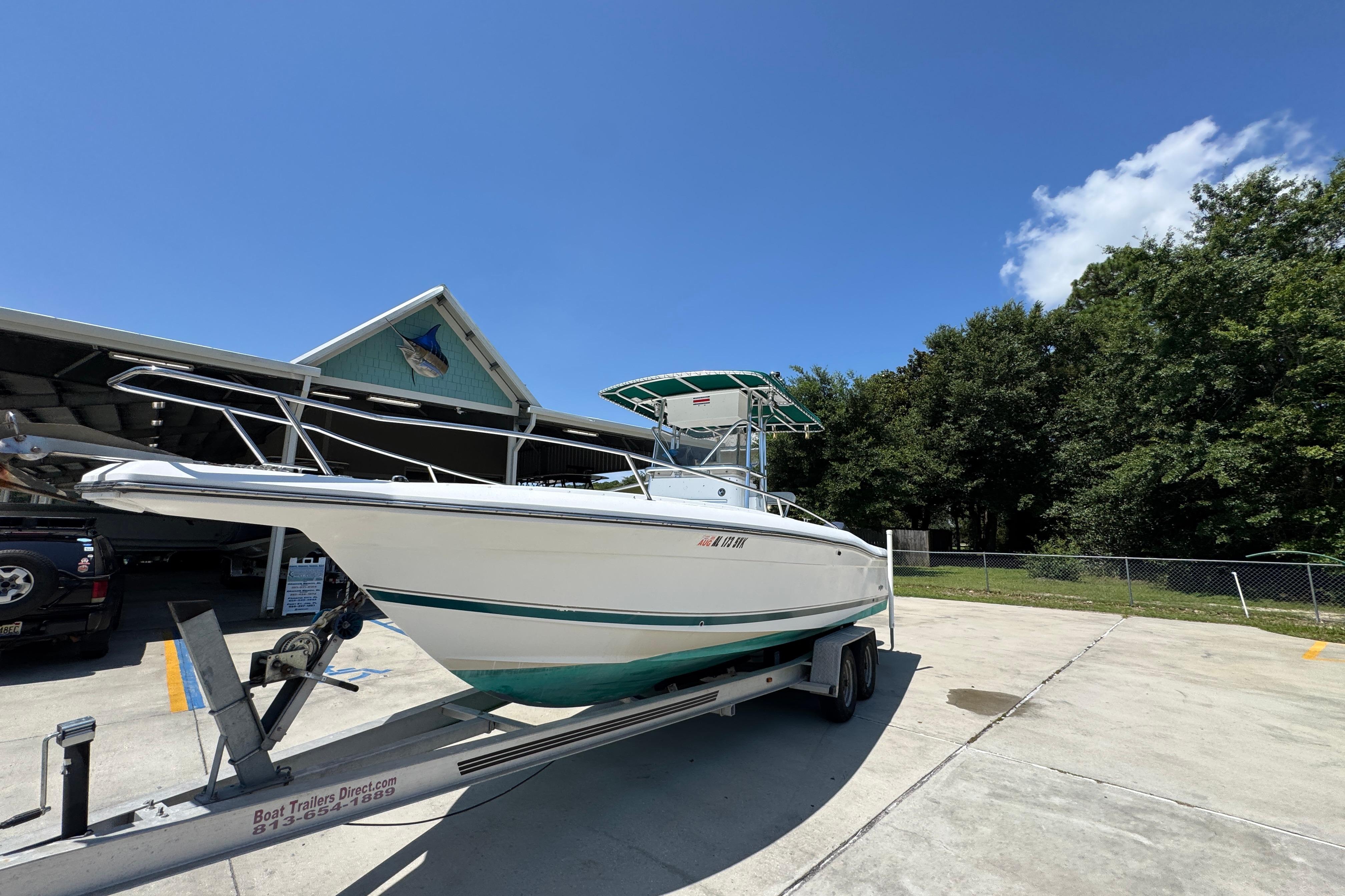 2000 Stamas 250 Tarpon boat on trailer, parked outdoors under clear blue sky.