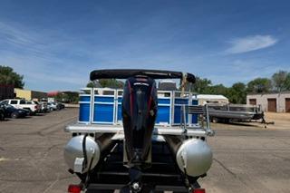 2026 Sun Tracker Fishin' Barge 20 DLX pontoon boat with outboard motor, parked outdoors.