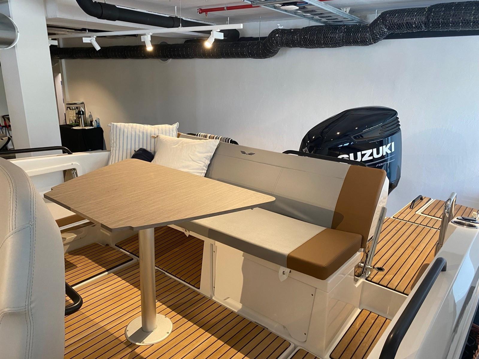 2022 Beneteau Flyer boat interior with seating, table, and Suzuki engine.