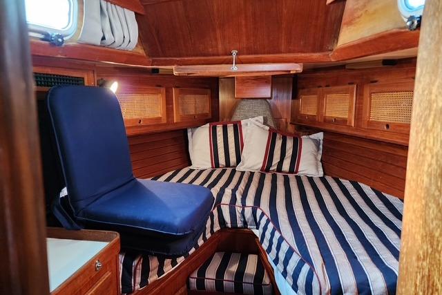 Cozy cabin interior of 1984 Bristol 45.5 Center Cockpit sailboat with striped bedding.