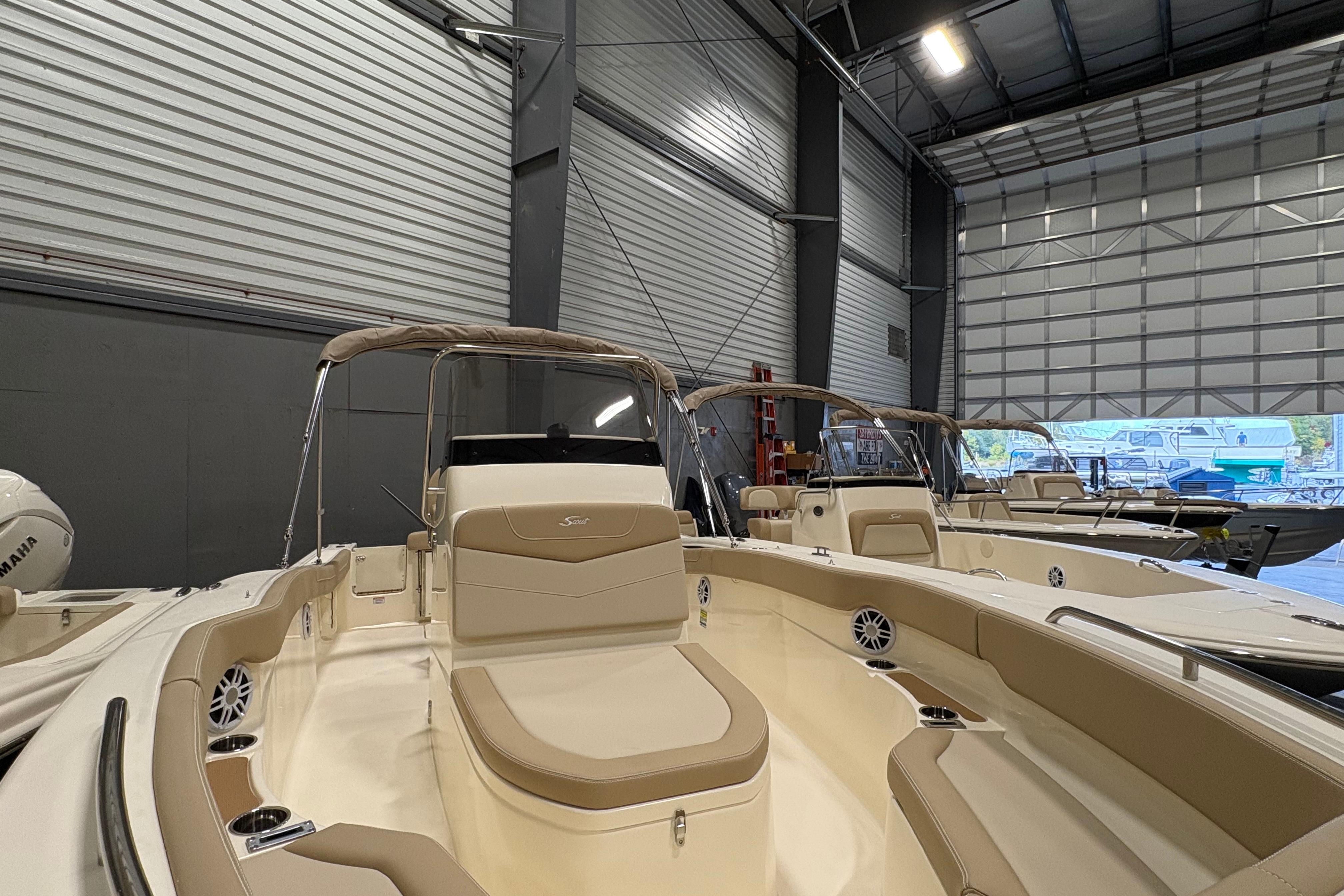 2025 Scout 215 XSF boat in a showroom, featuring sleek design and comfortable seating.