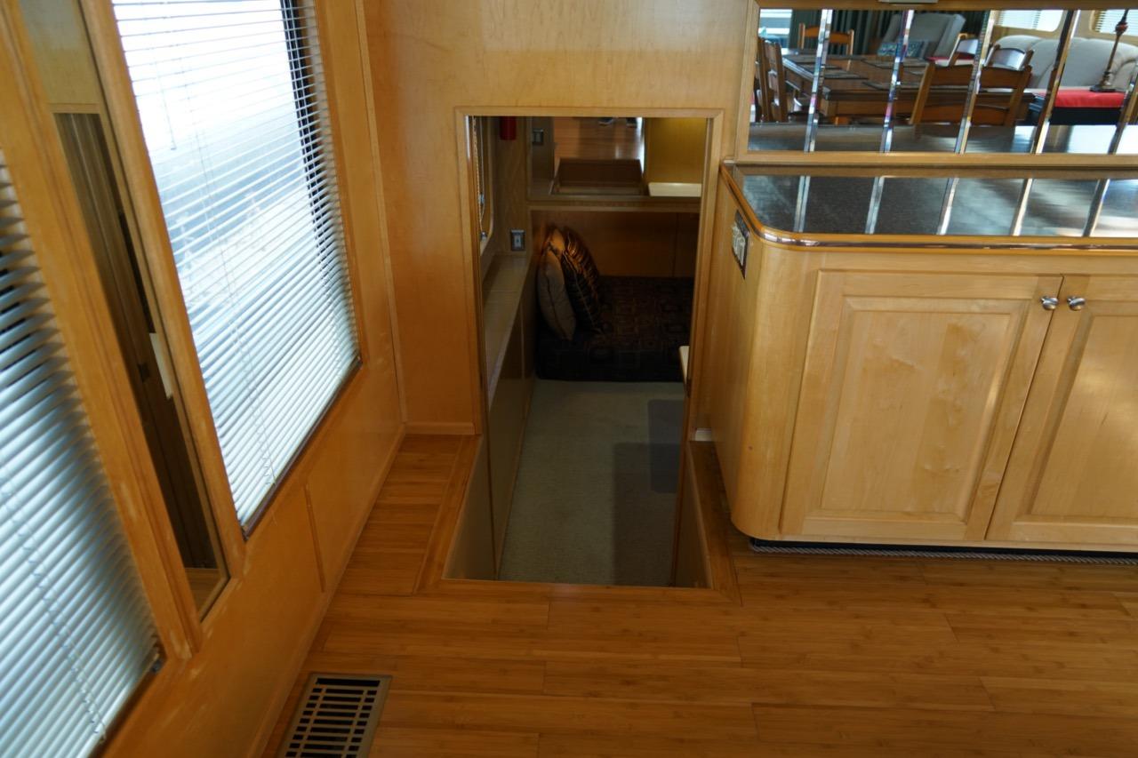 Interior of 2000 Stardust Cruisers houseboat with wooden flooring and cabinetry.