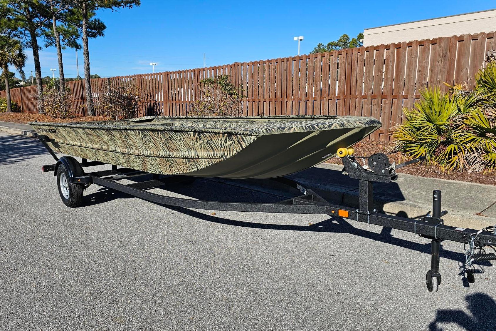 2025 Tracker Grizzly 1860 Utility boat on trailer, parked outdoors.