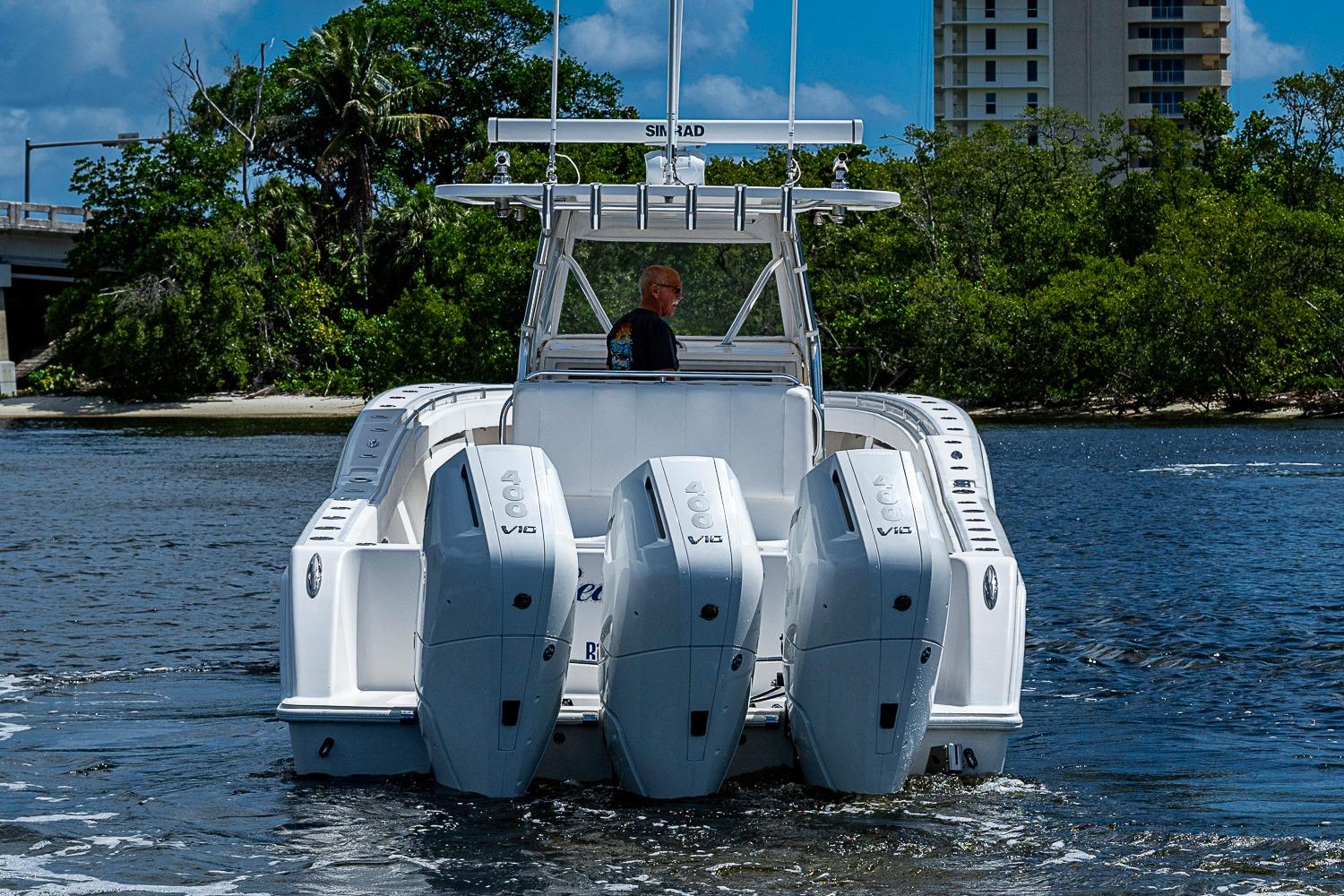 2015 Invincible 42 Open Fisherman boat with four powerful engines on the water.