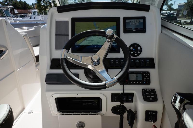 2023 Sailfish 245 DC boat dashboard with steering wheel and navigation display.