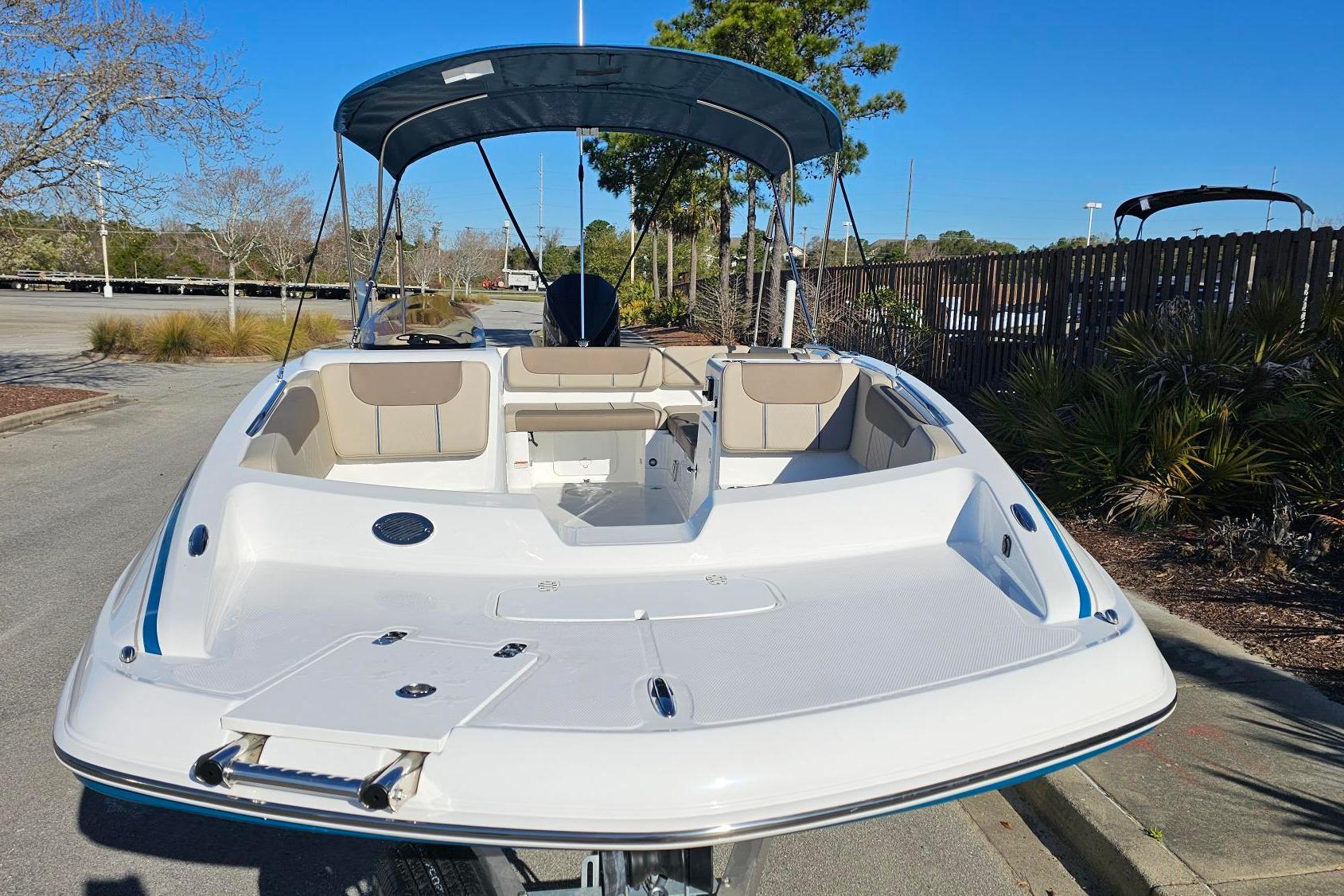 2026 Tahoe 2150 boat with canopy, parked on a sunny day, showcasing spacious seating.