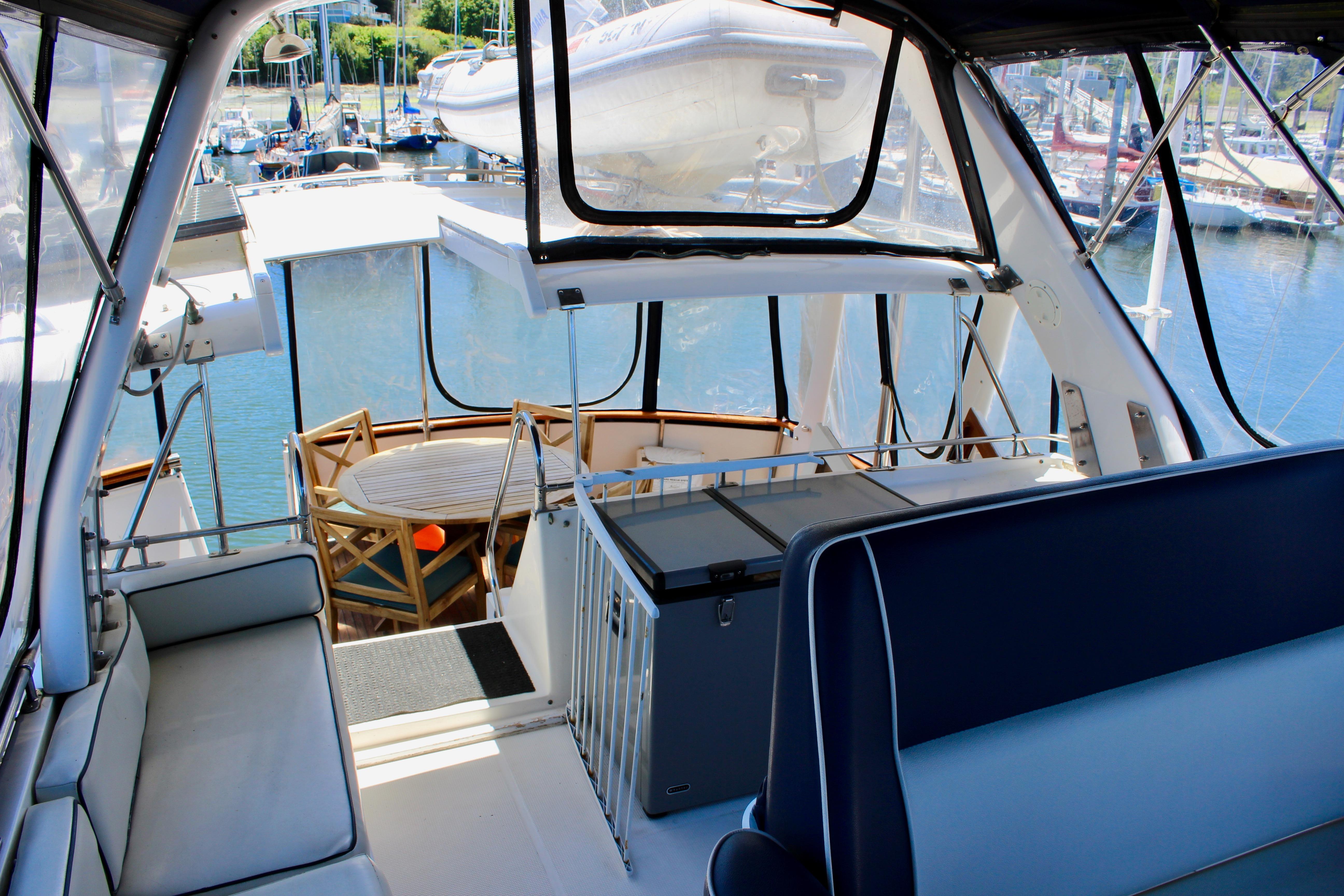Interior view of 1986 Kha Shing Spindrift 46 yacht with seating and marina backdrop.