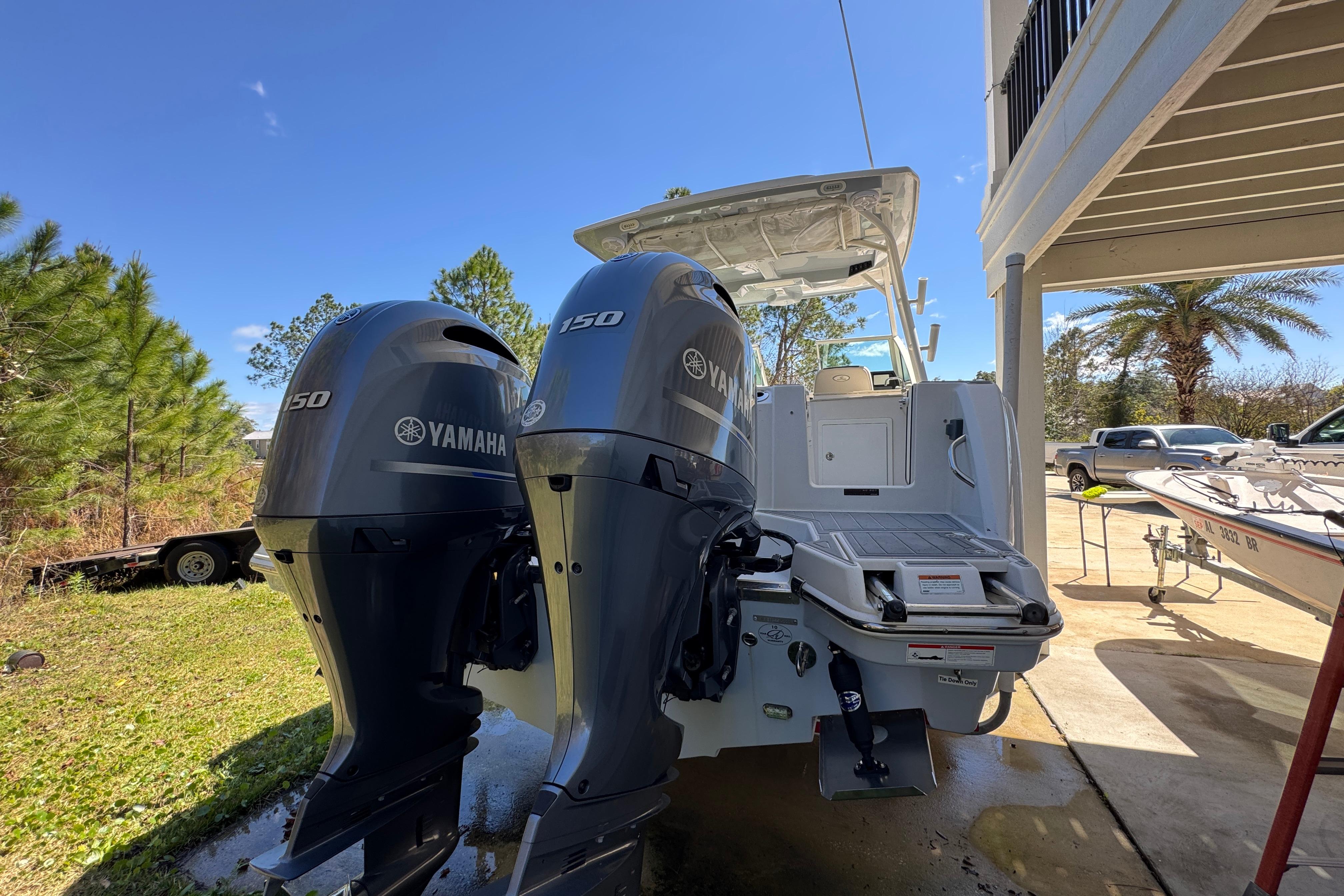 2022 Sailfish 276 DC boat with dual Yamaha 150 engines, parked outdoors.