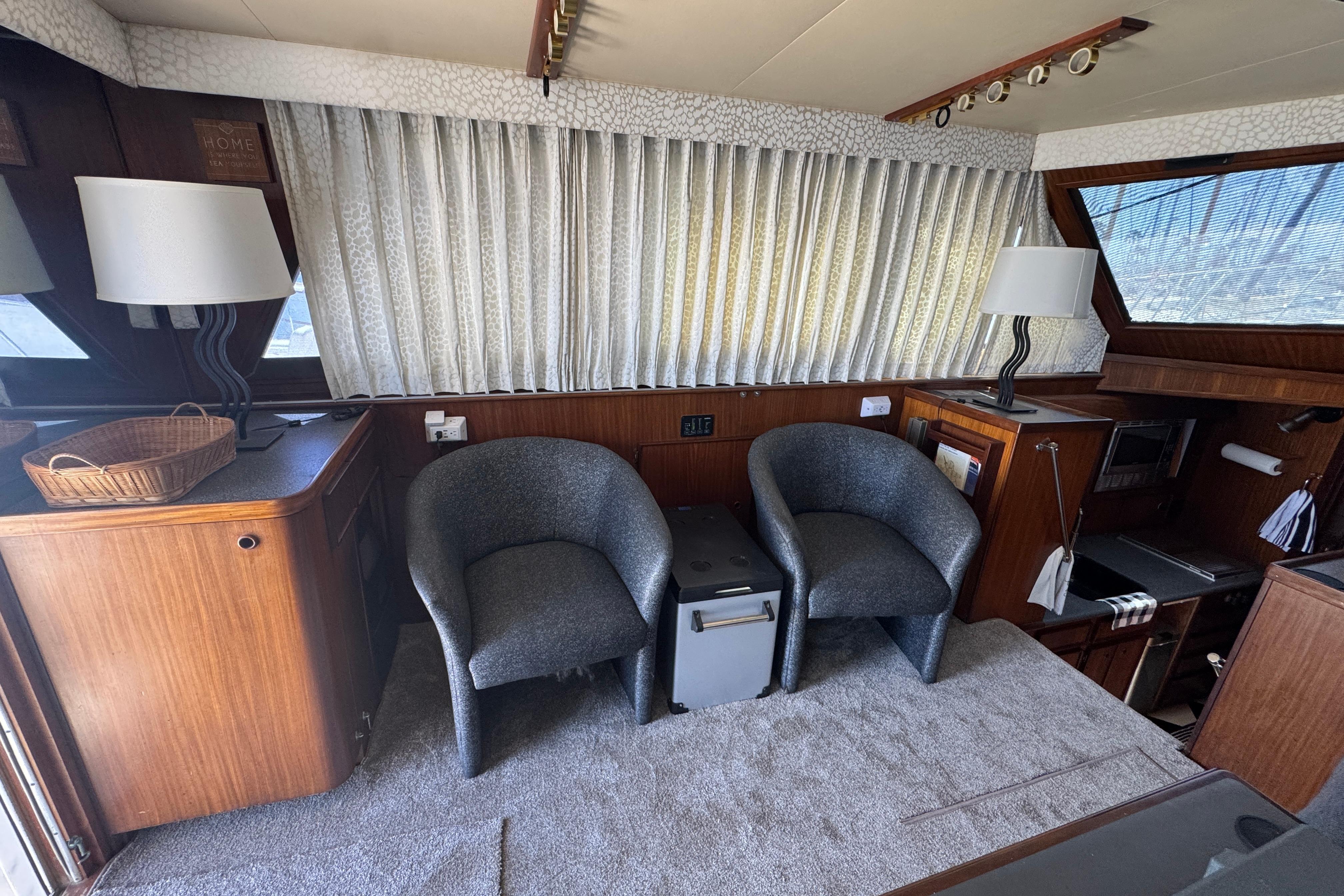 Interior of 1985 Hatteras 45 Convertible yacht with chairs and wooden cabinetry.
