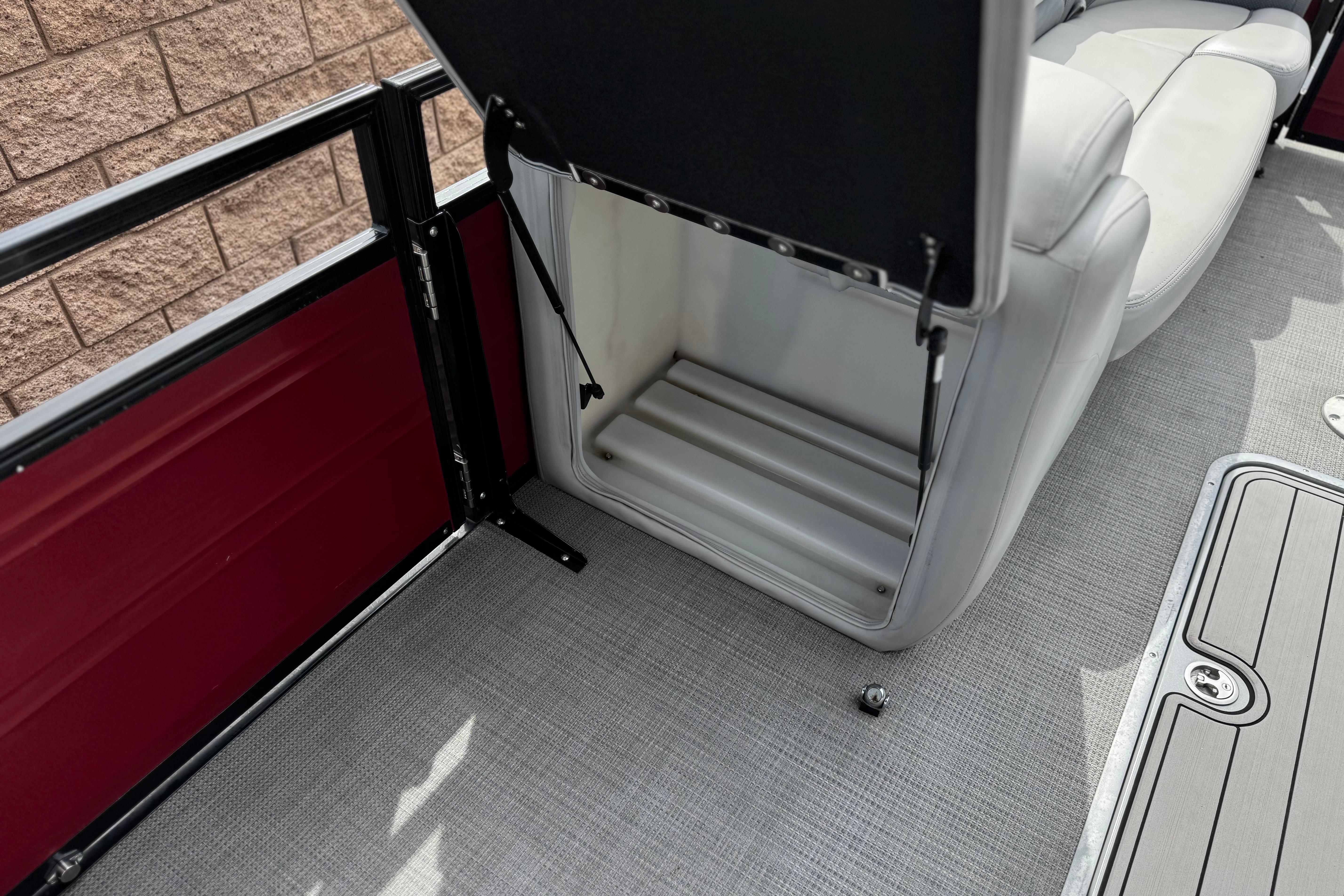 2022 Regency 250 DL3 boat interior with open storage compartment and cushioned seating.