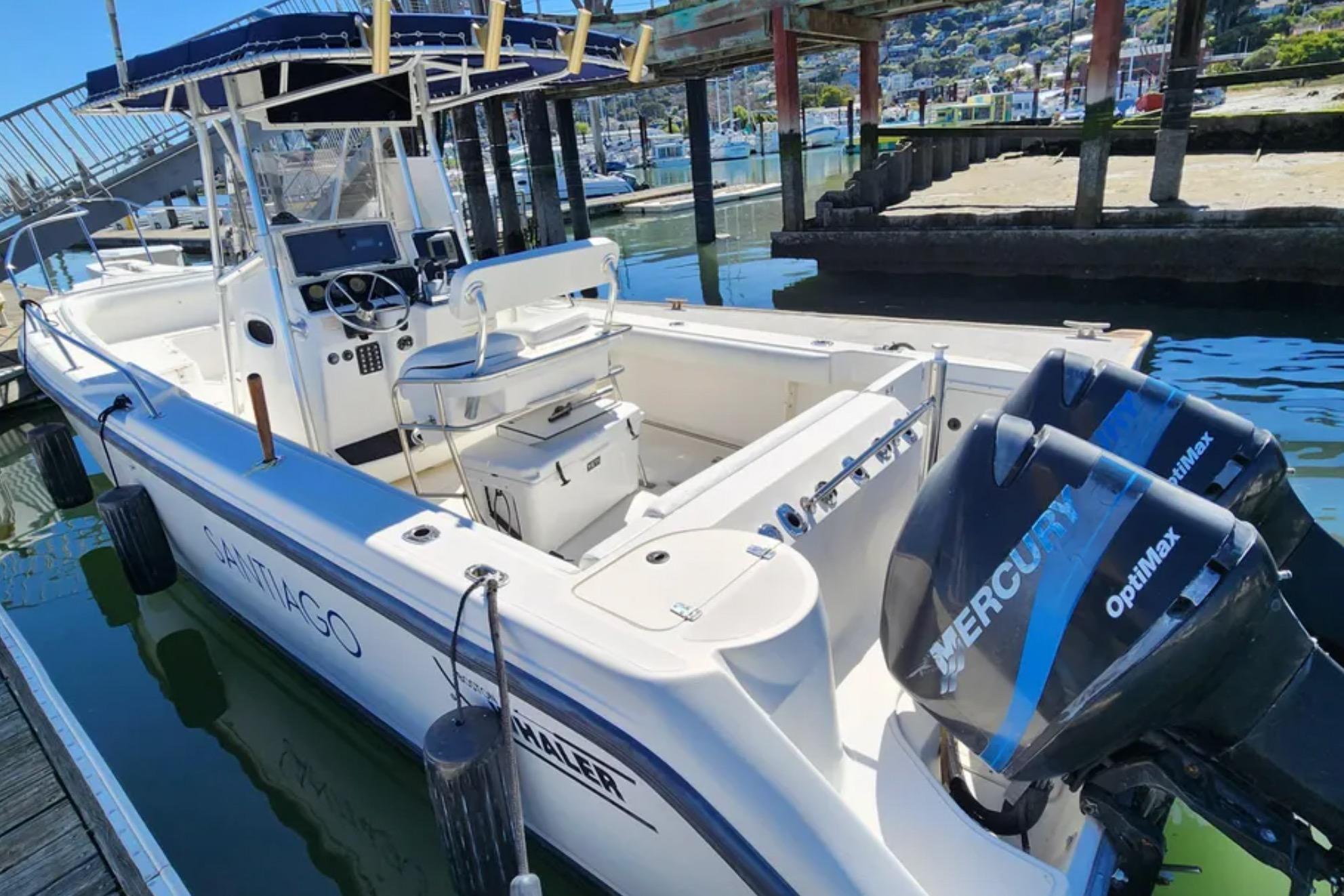 2001 Boston Whaler 26 Outrage boat docked with twin Mercury OptiMax engines.