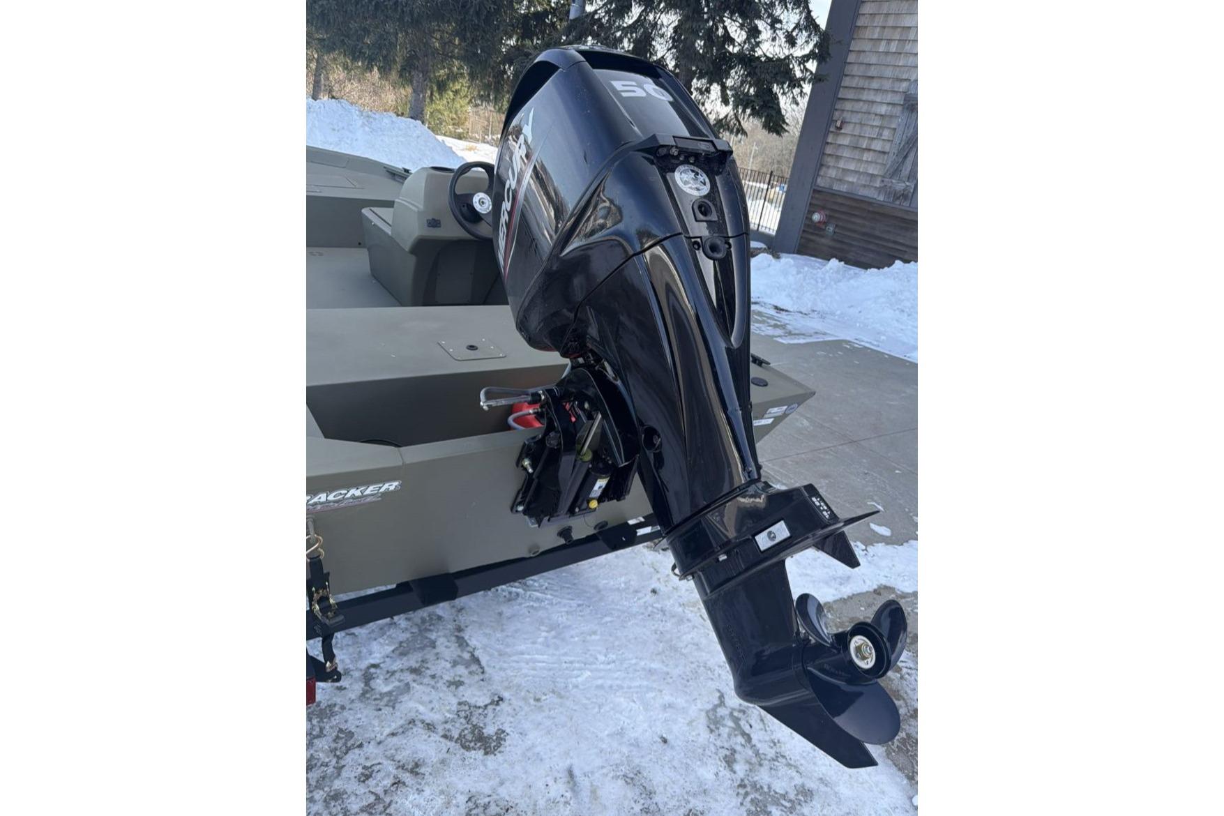 2026 Tracker Grizzly 1648 SC boat with powerful outboard motor in snowy setting.