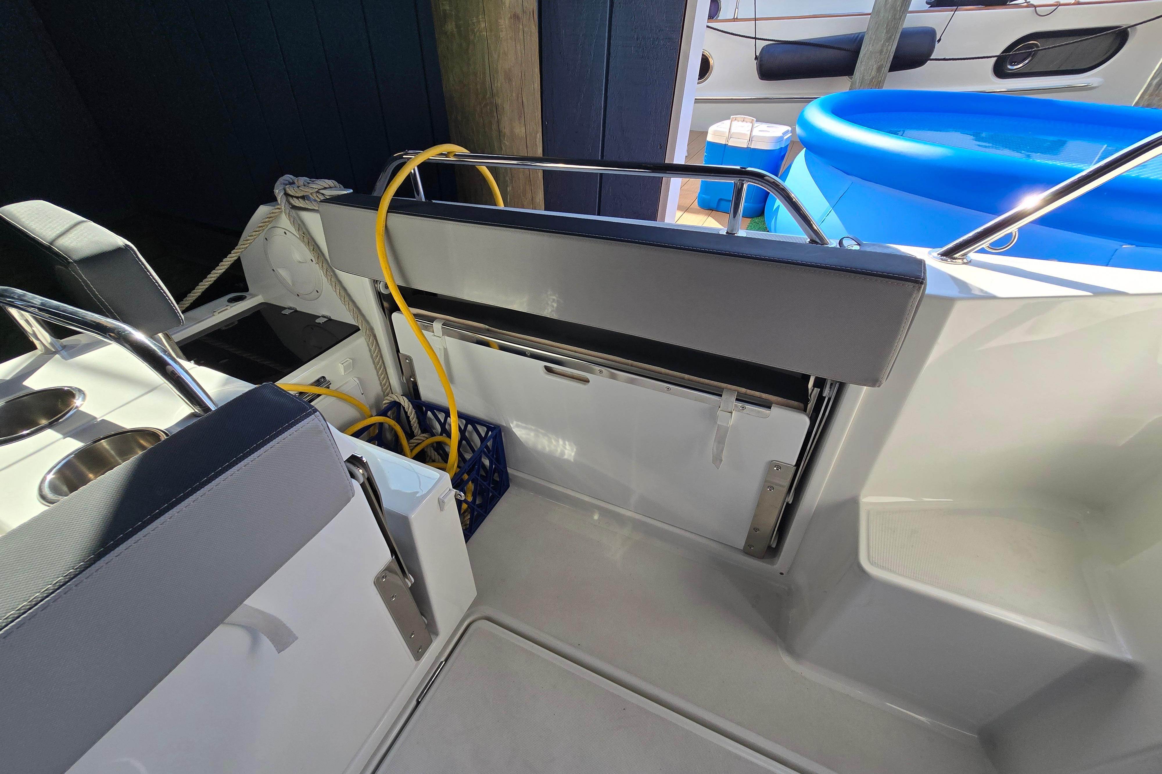 The image shows the stern of a Jeanneau NC Sport 895 boat with seating area and railing.