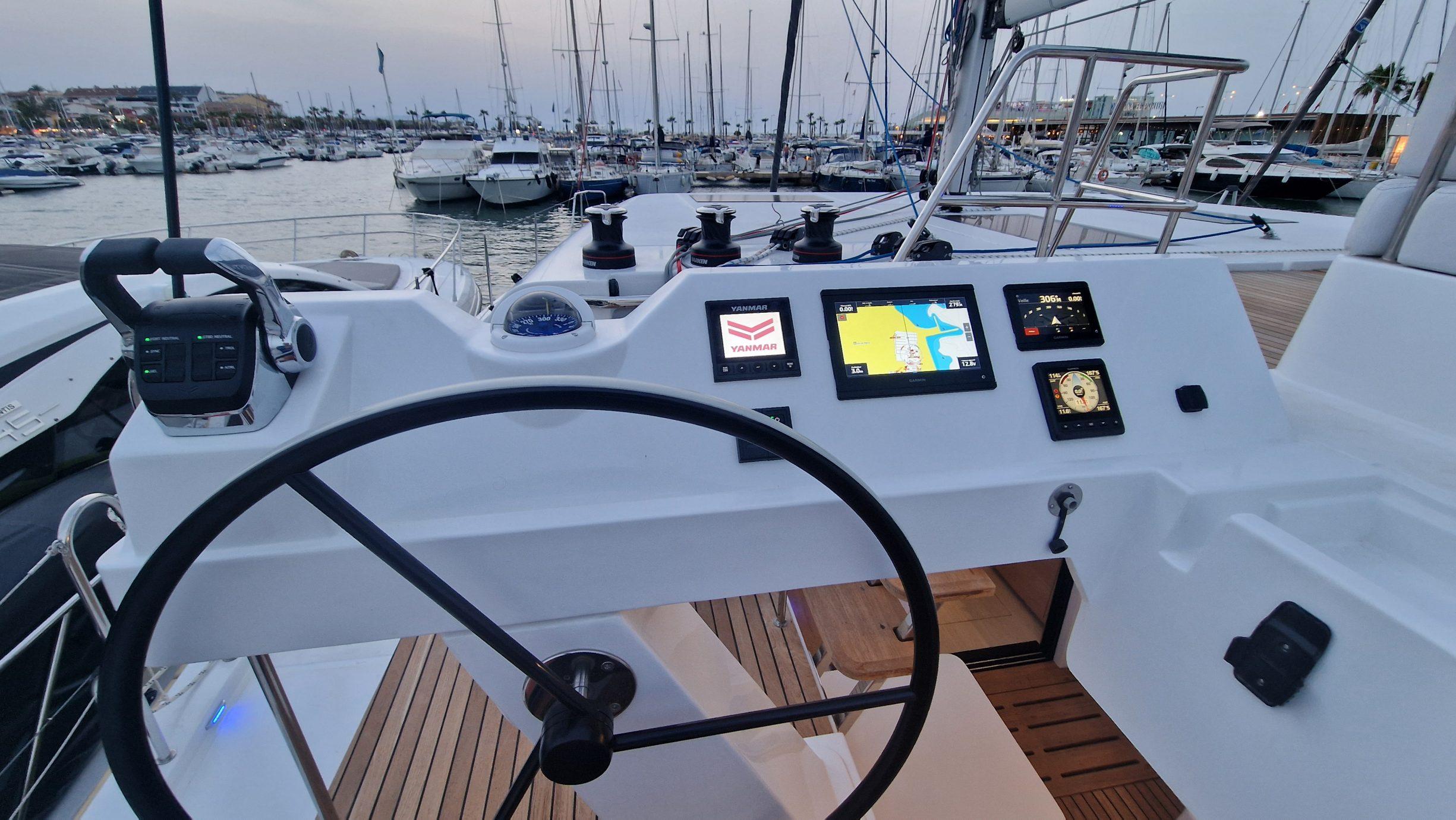 Helm of 2026 Aventura 45 yacht with navigation screens and marina view.