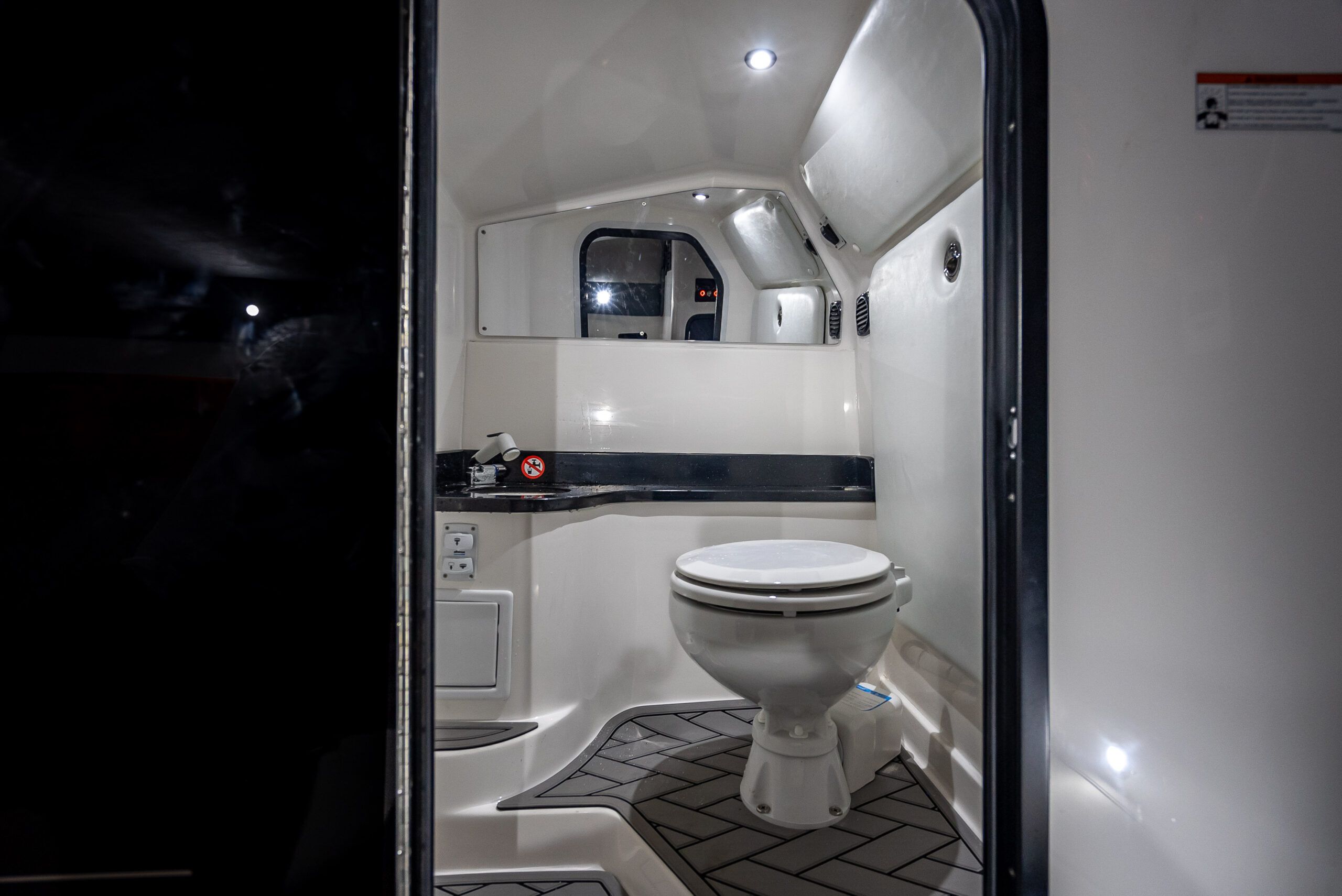 The image shows a modern boat bathroom with a toilet and sink.