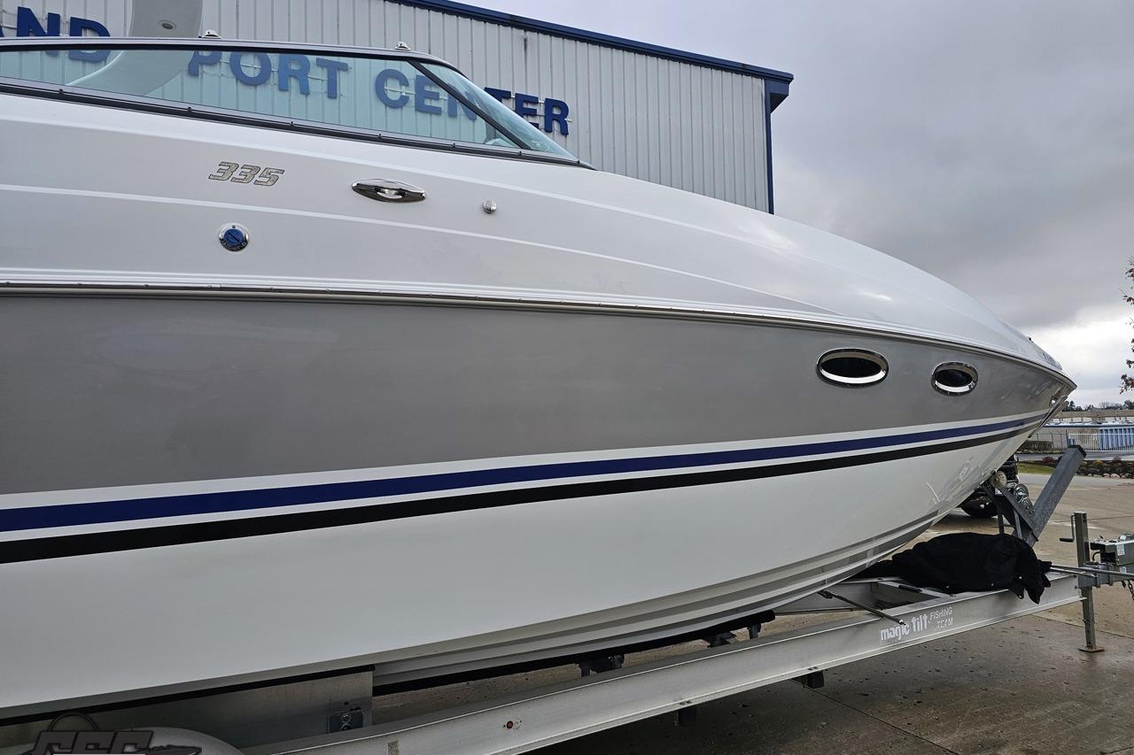 2008 Baja 335 Performance boat on trailer, parked near a port center building.