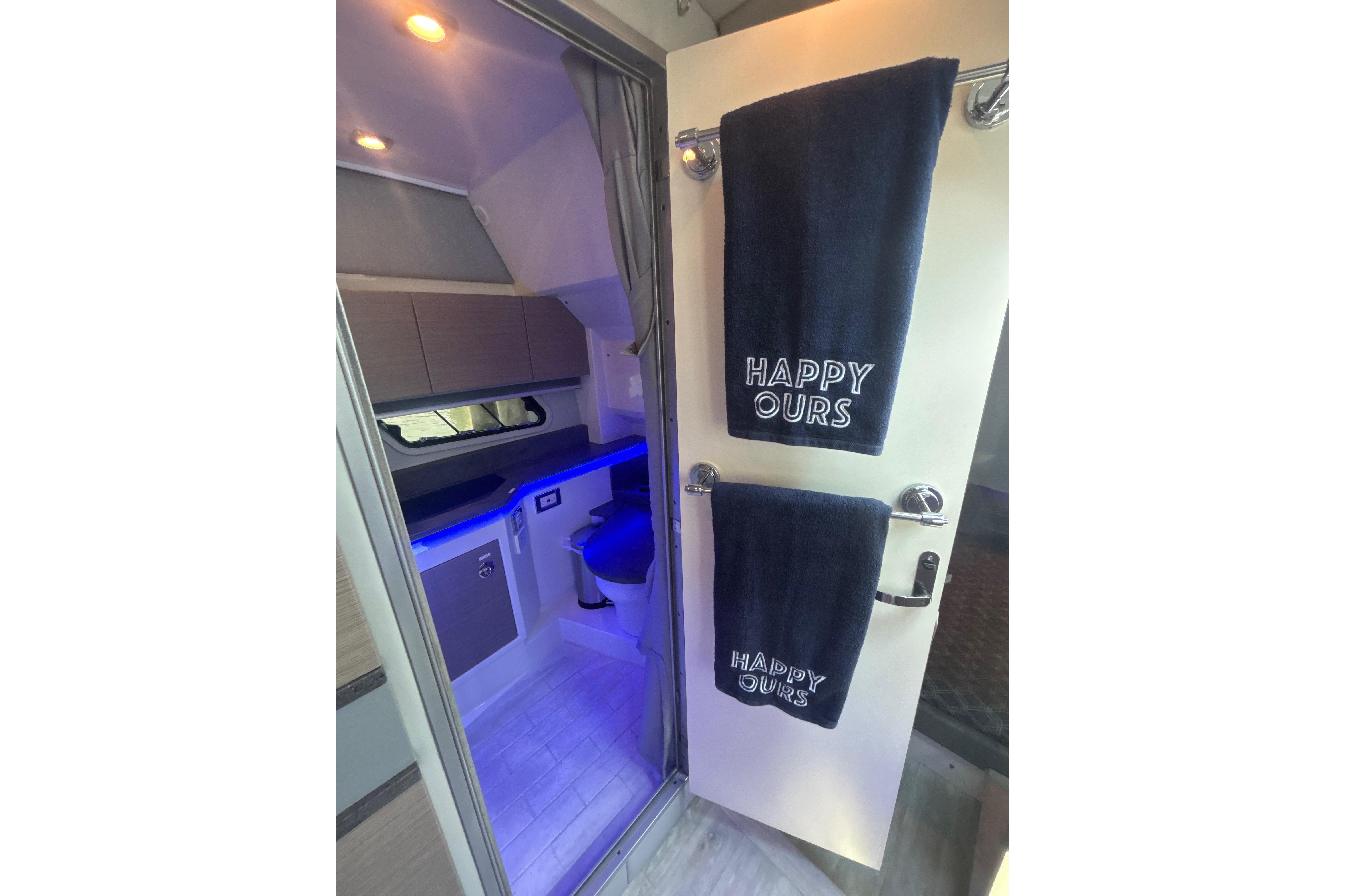 Interior of 2019 Formula 430 Super Sport Crossover with modern bathroom and "Happy Ours" towels.