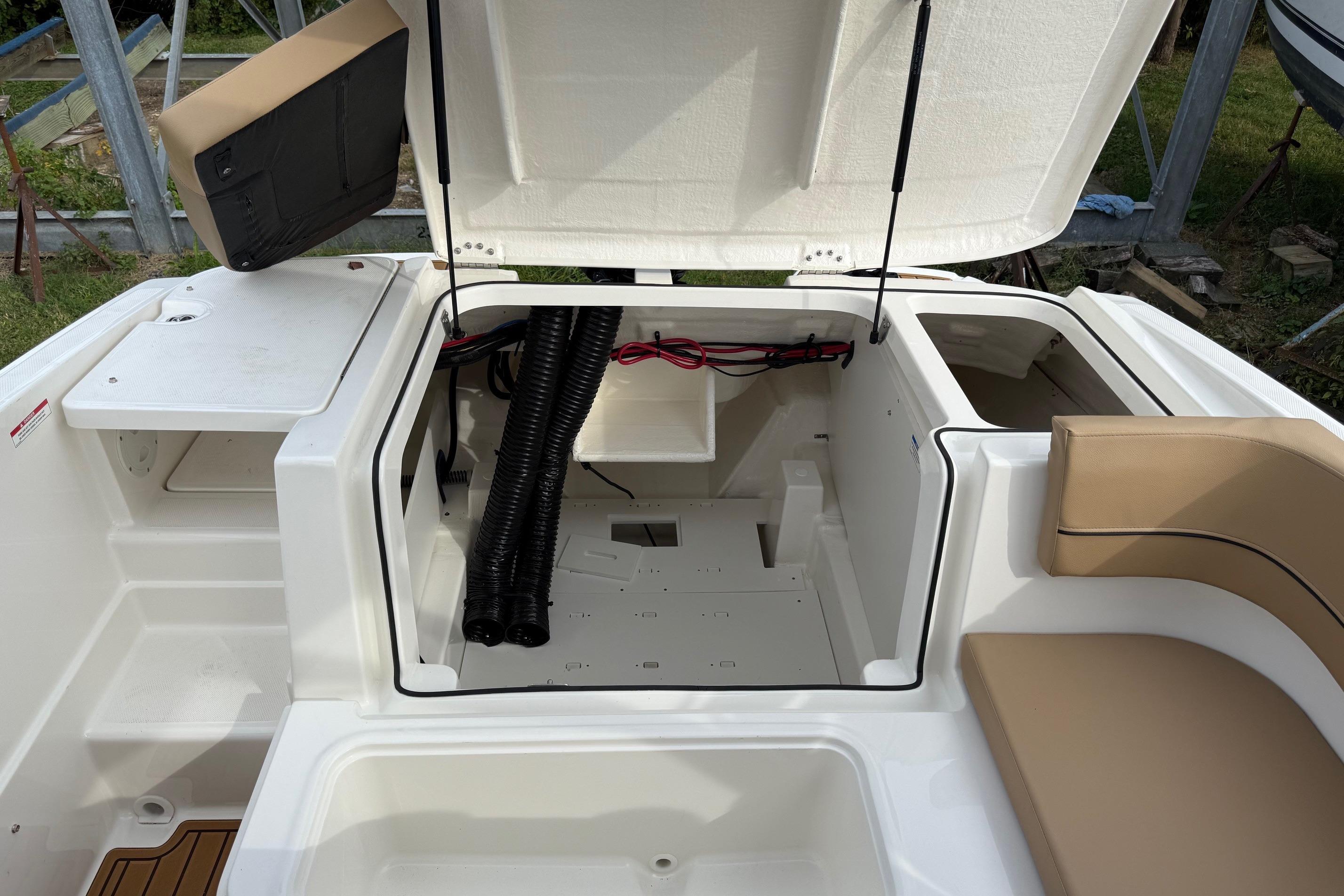 2026 Bayliner VR6 Bowrider OB interior storage compartment with open hatch and seating area.