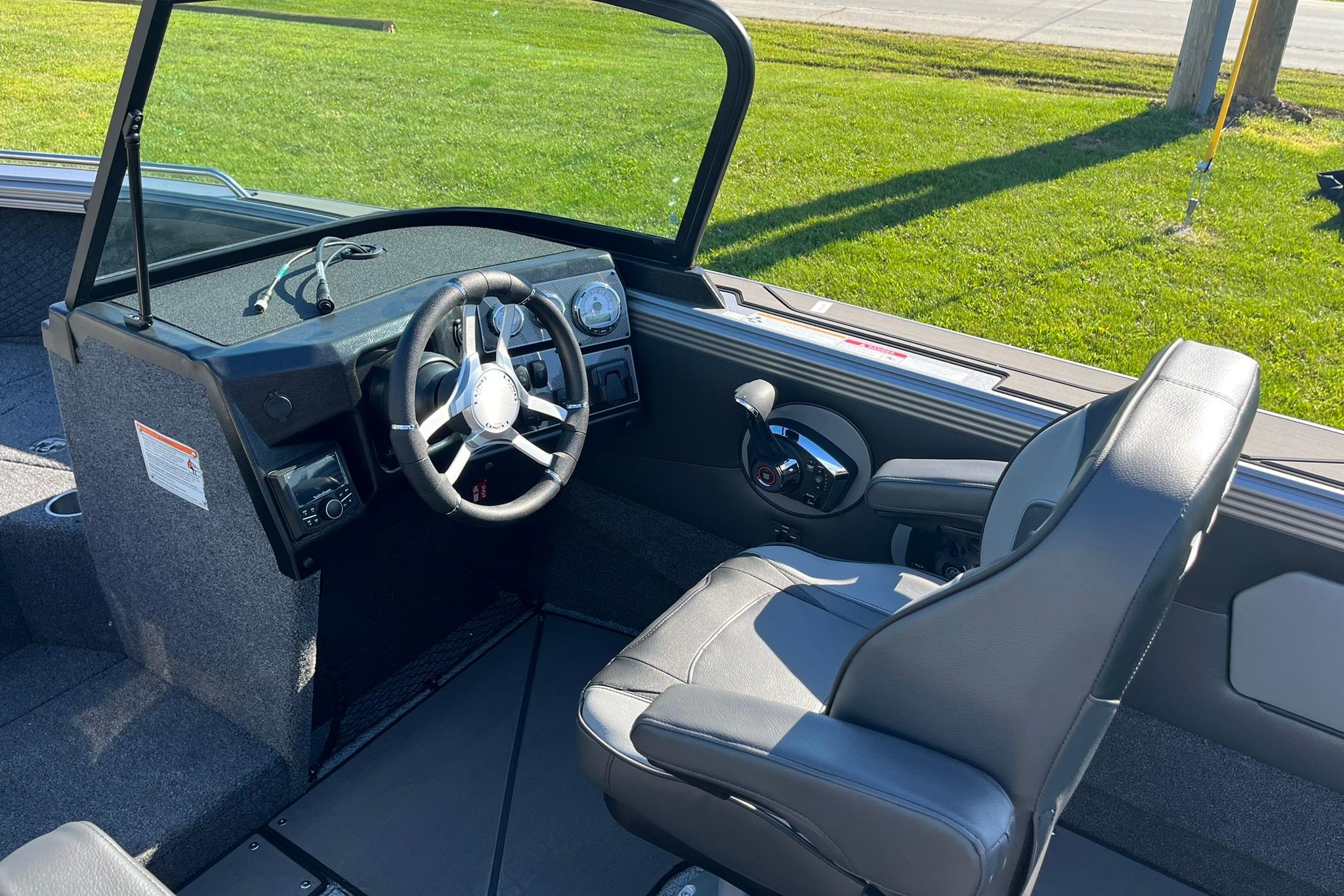 2026 Lund 2275 Baron boat interior with steering wheel and captain's seat.