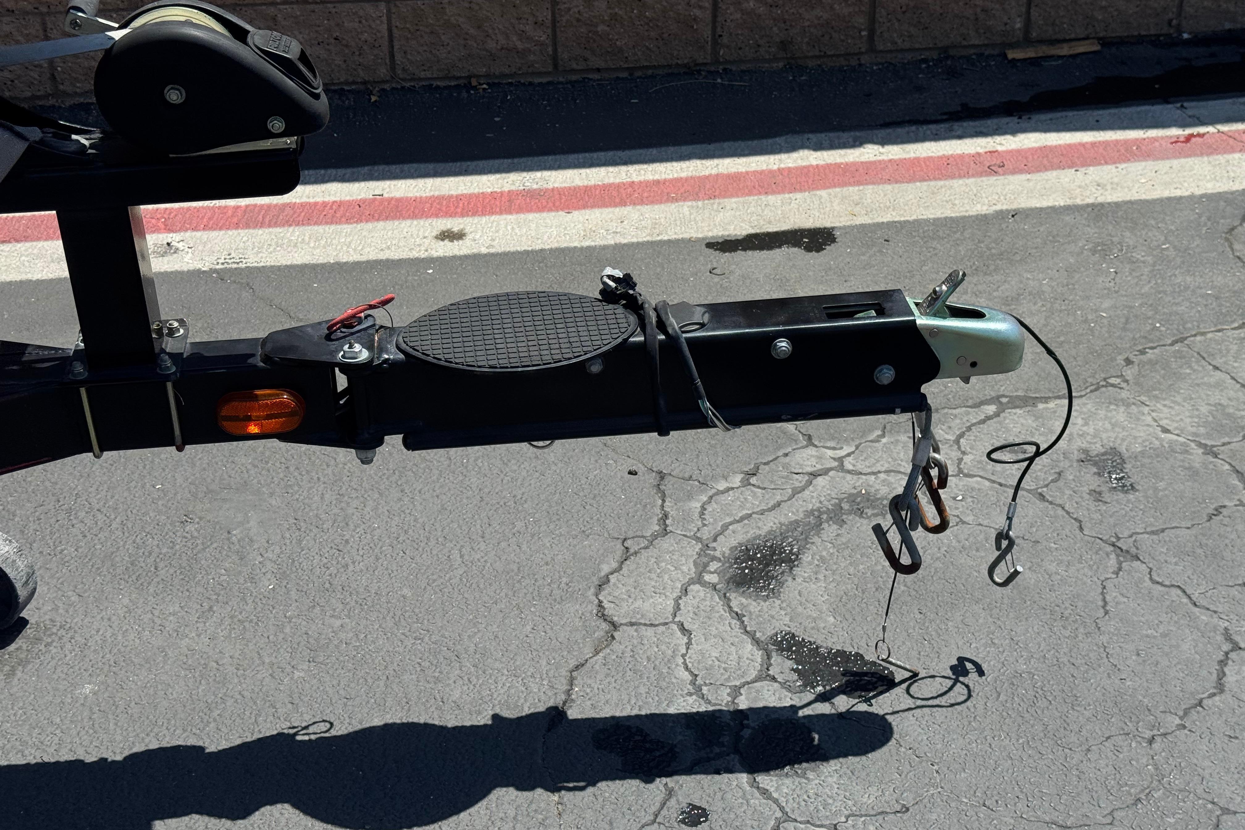 Trailer hitch of a 2012 Nitro Z-7 boat on asphalt pavement.