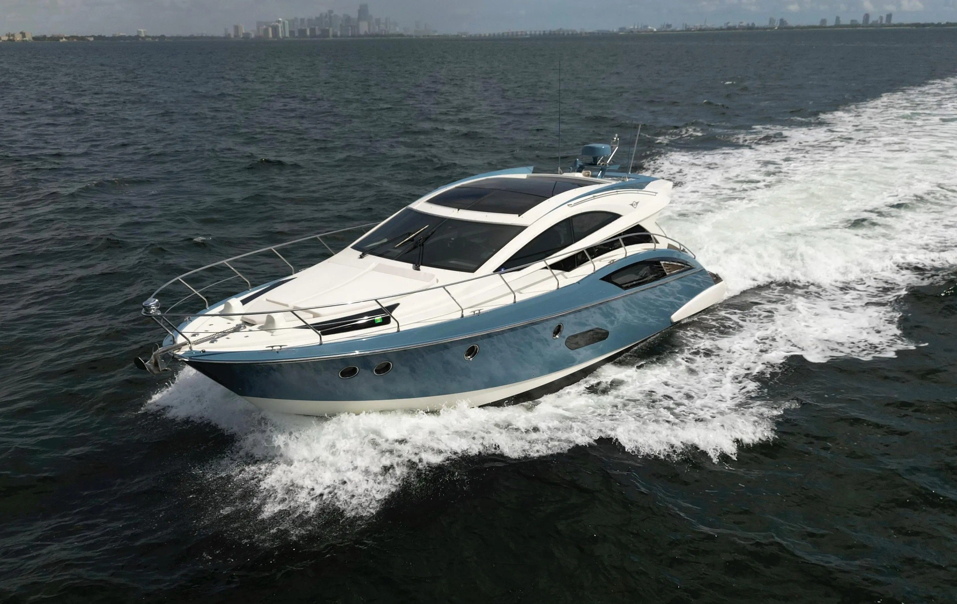 2010 Marquis Sport Coupe on the water with city skyline in the background.