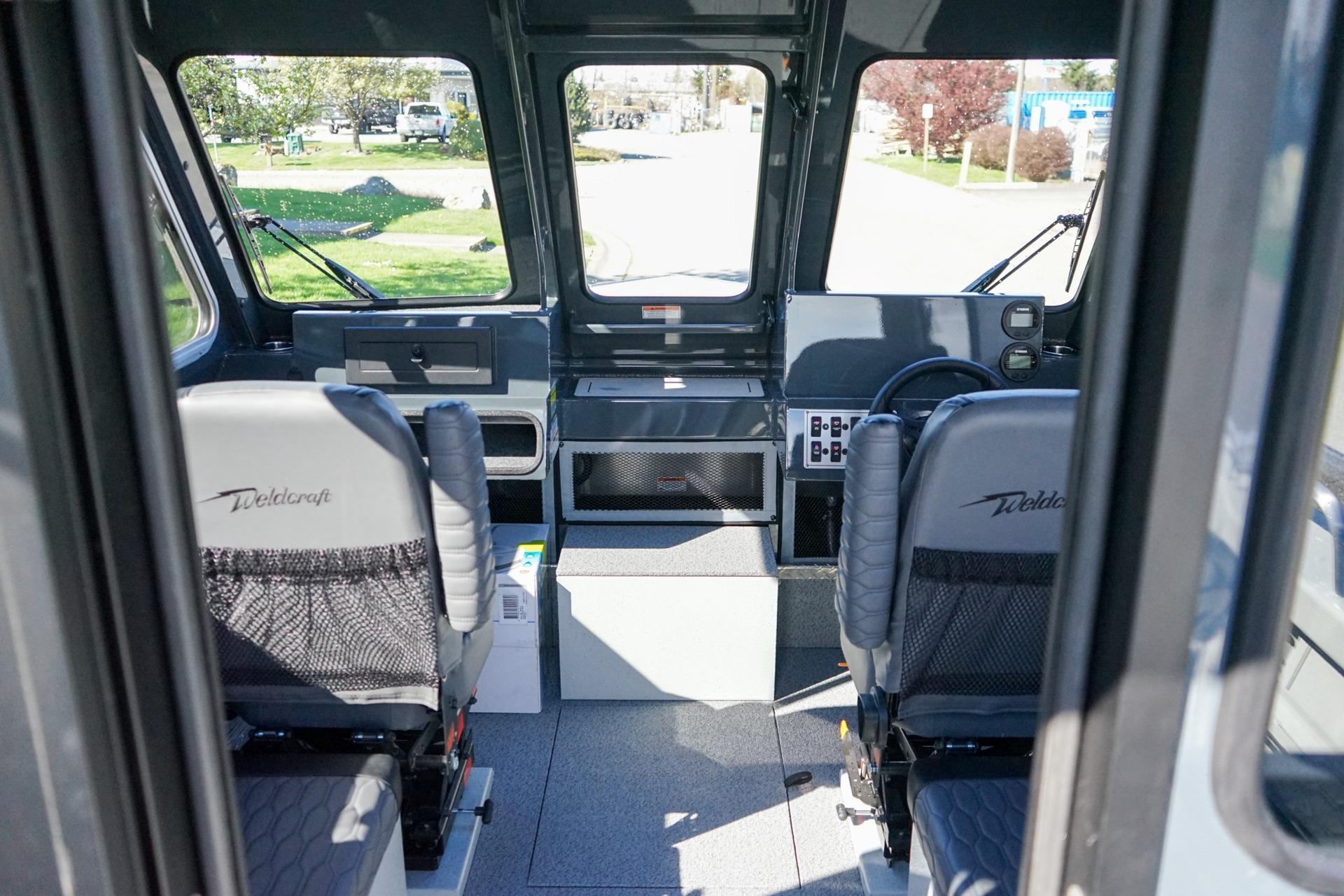 Interior of 2026 Weldcraft 210 Revolution boat with two seats and control panel.