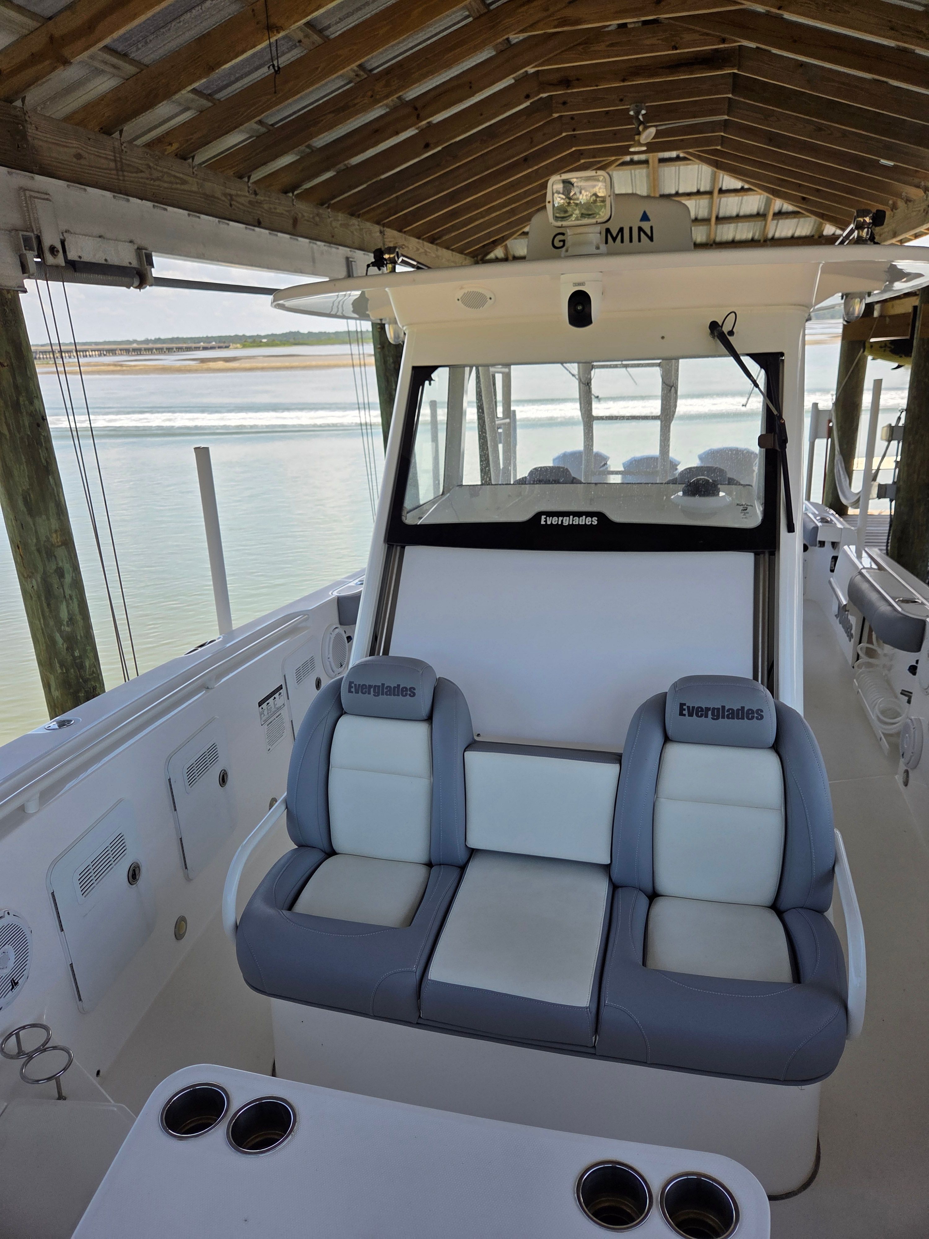 The image shows the cockpit of a 2017 Everglades 355 Center Console boat docked under a covered area.