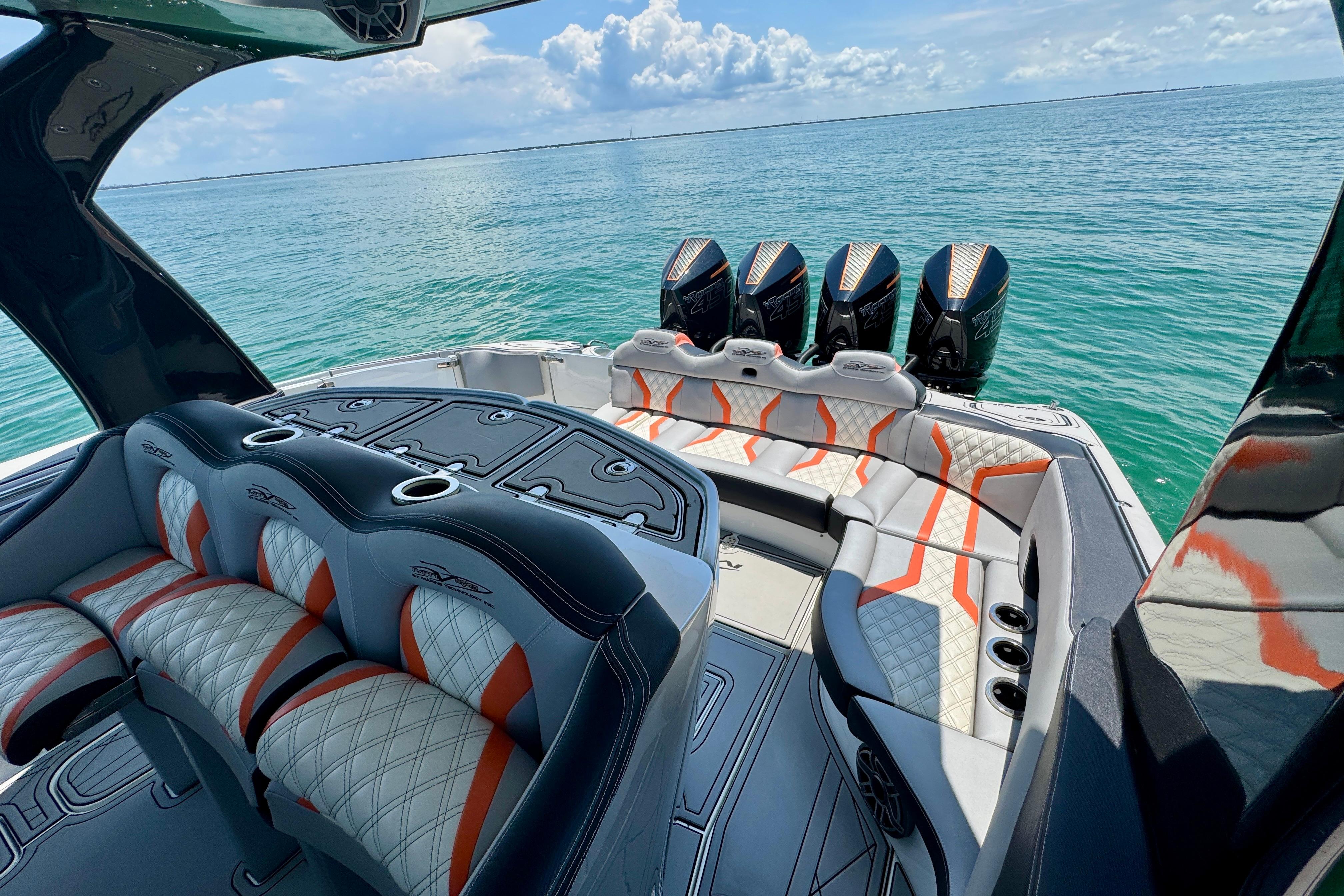 Luxurious 2017 MTI V42 boat interior with plush seating and multiple engines on open water.