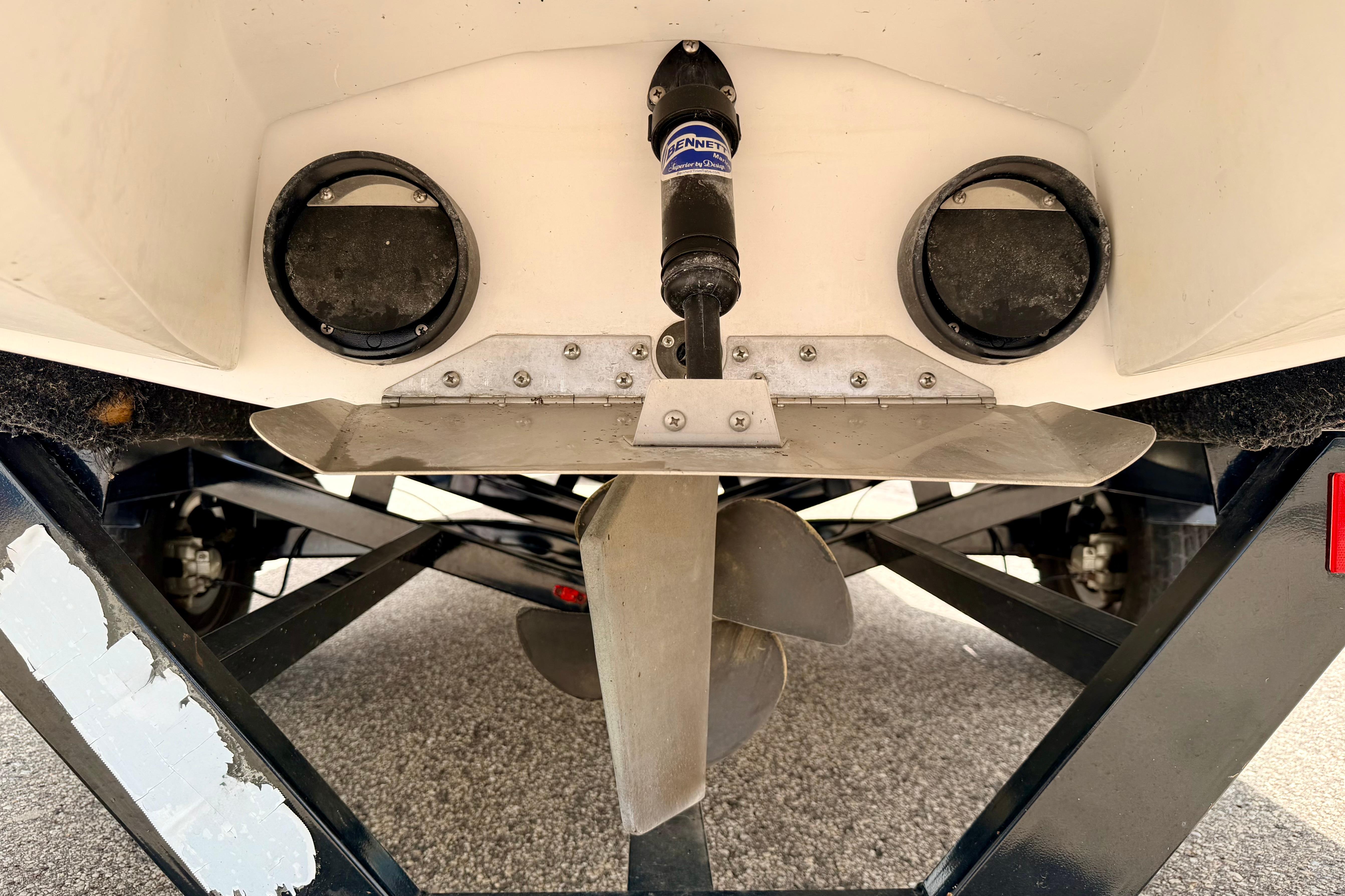 2014 Tigé R20 boat propeller and trim tab detail on trailer.