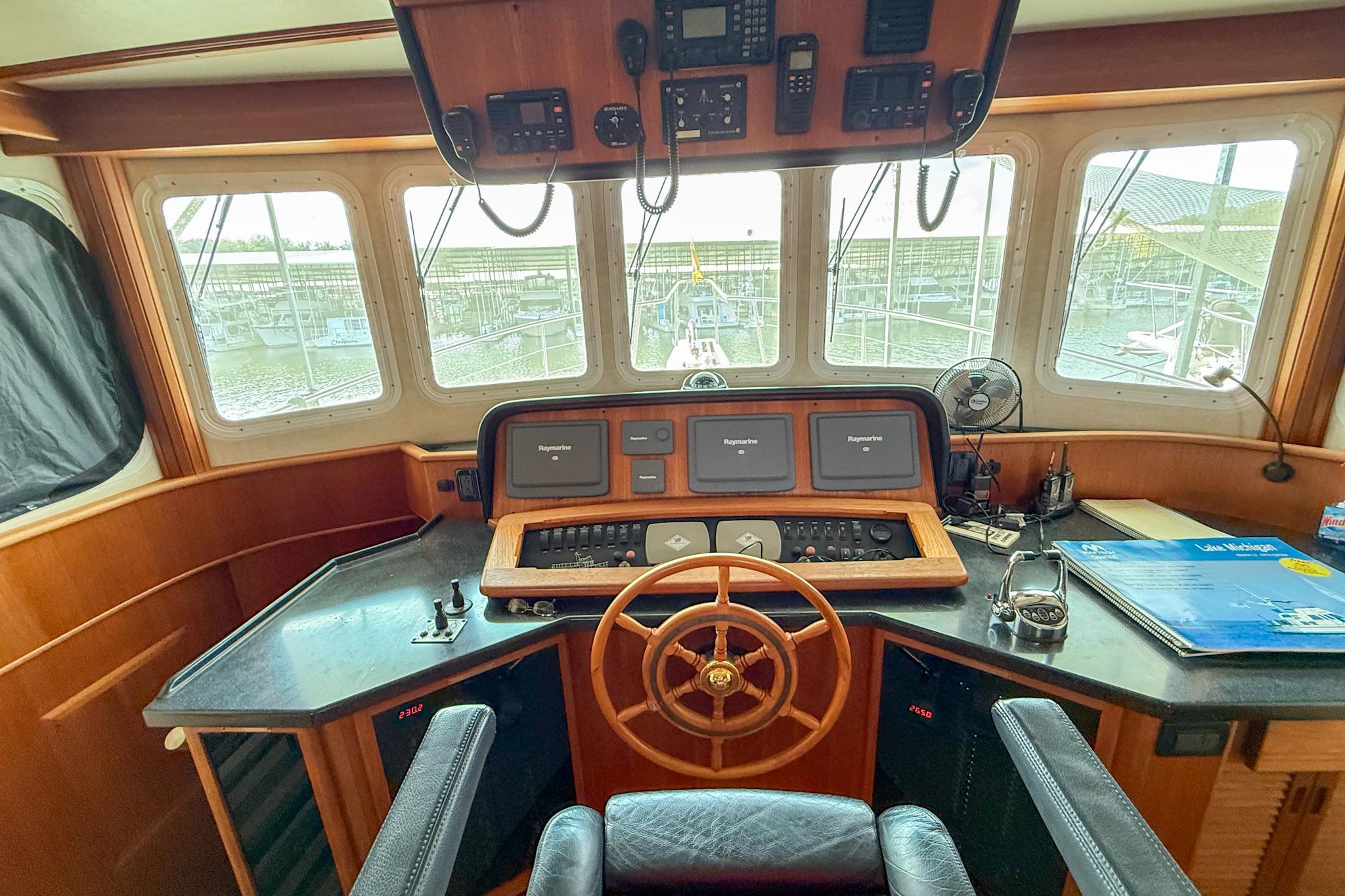 Pilothouse of 2007 Nordic Tug 54 with navigation equipment and steering wheel.