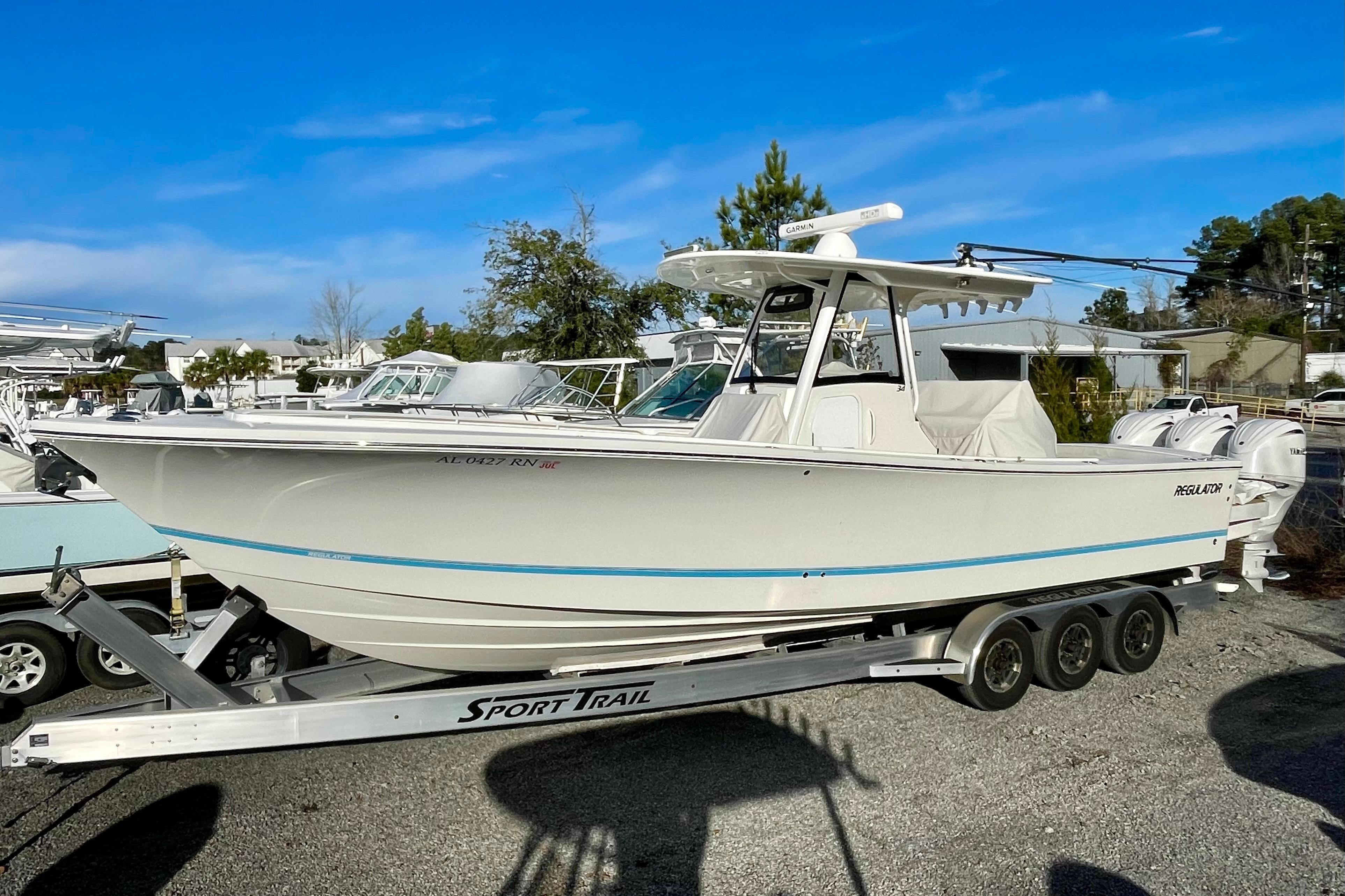 2023 Regulator 34 boat on trailer, parked outdoors under clear blue sky.