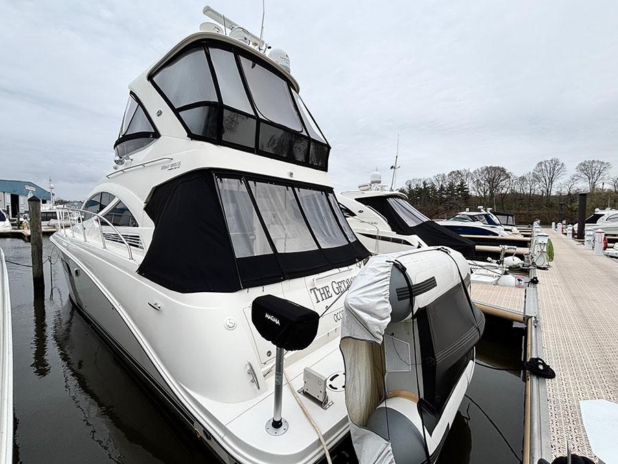 Sea Ray 450 Sedan Bridge 2013 yacht docked at marina, featuring sleek design and covered upper deck.