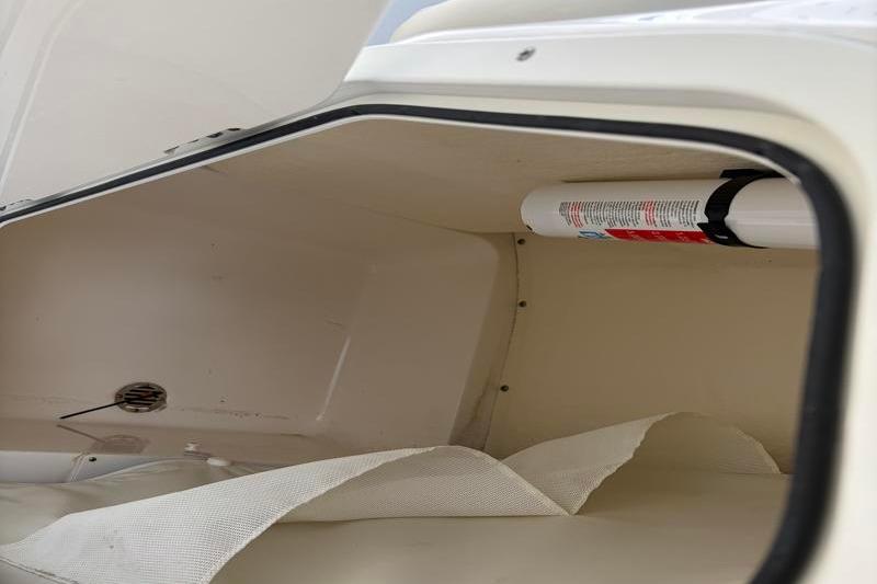 Storage compartment of 2025 Key West 210 Bay Reef boat with fire extinguisher.