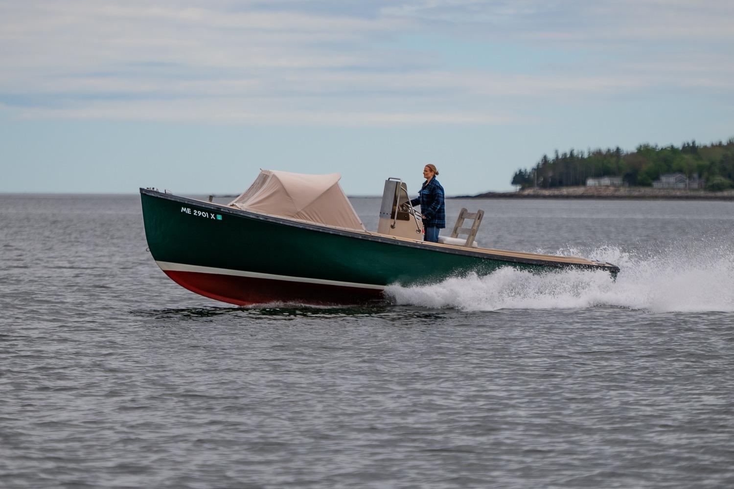 1989 Ellis 24 Open boat cruising on calm waters with a person steering.