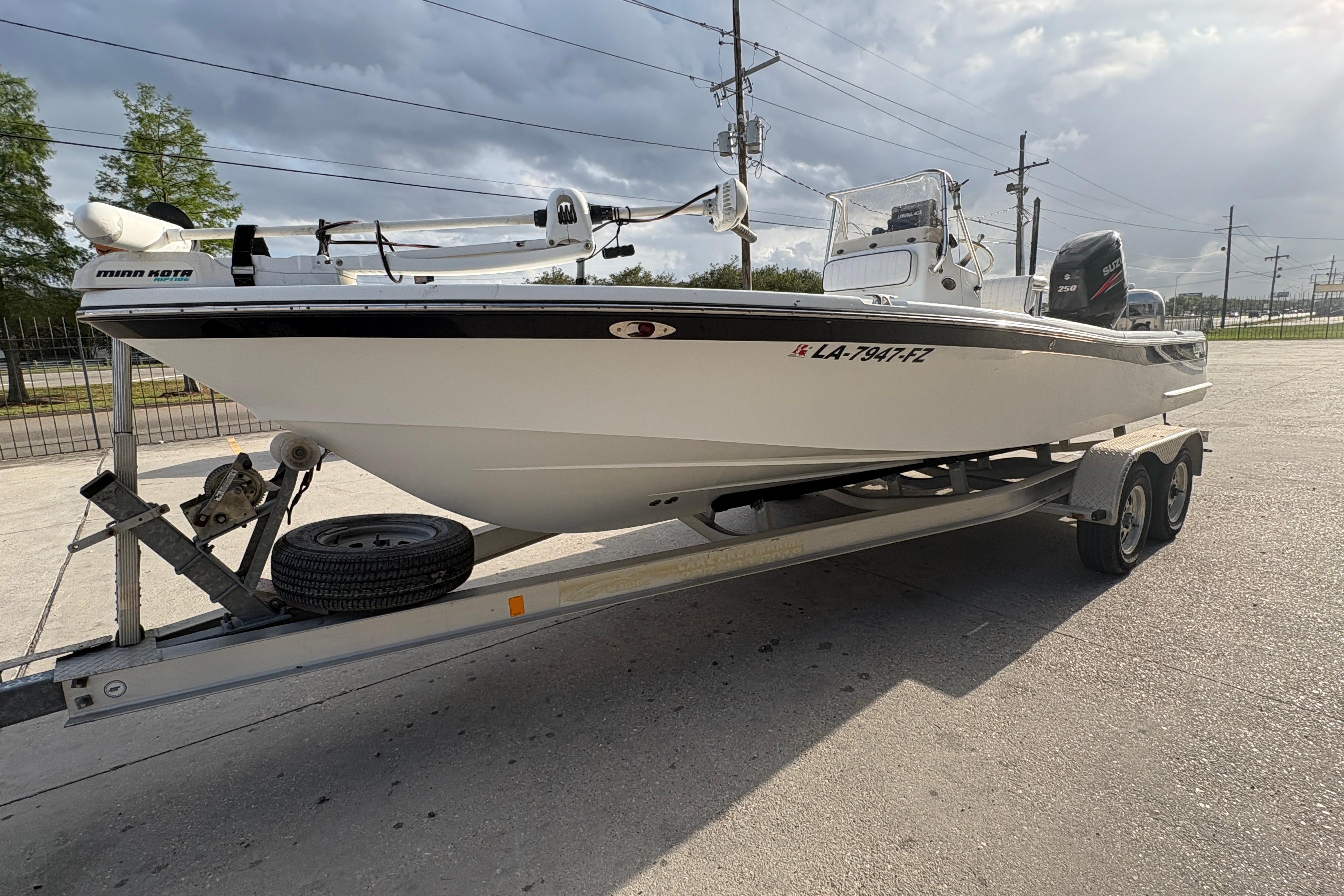2012 BlackJack 224 boat on trailer, featuring Minn Kota motor, parked outdoors.