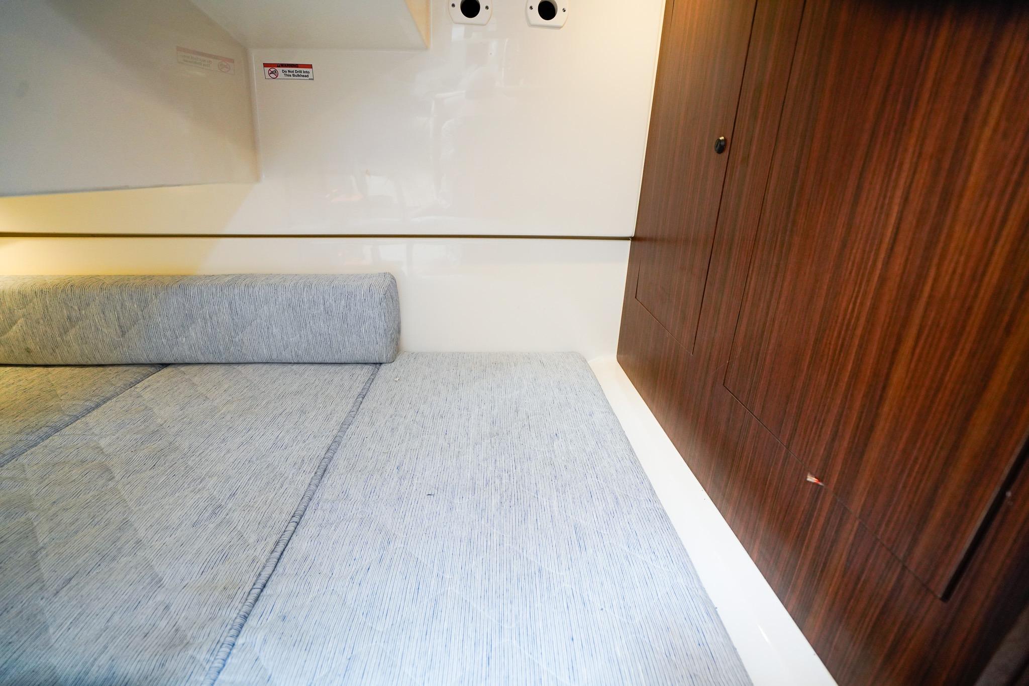 Interior cabin of 2020 Pursuit OS 325 Offshore with wooden paneling and cushioned seating.