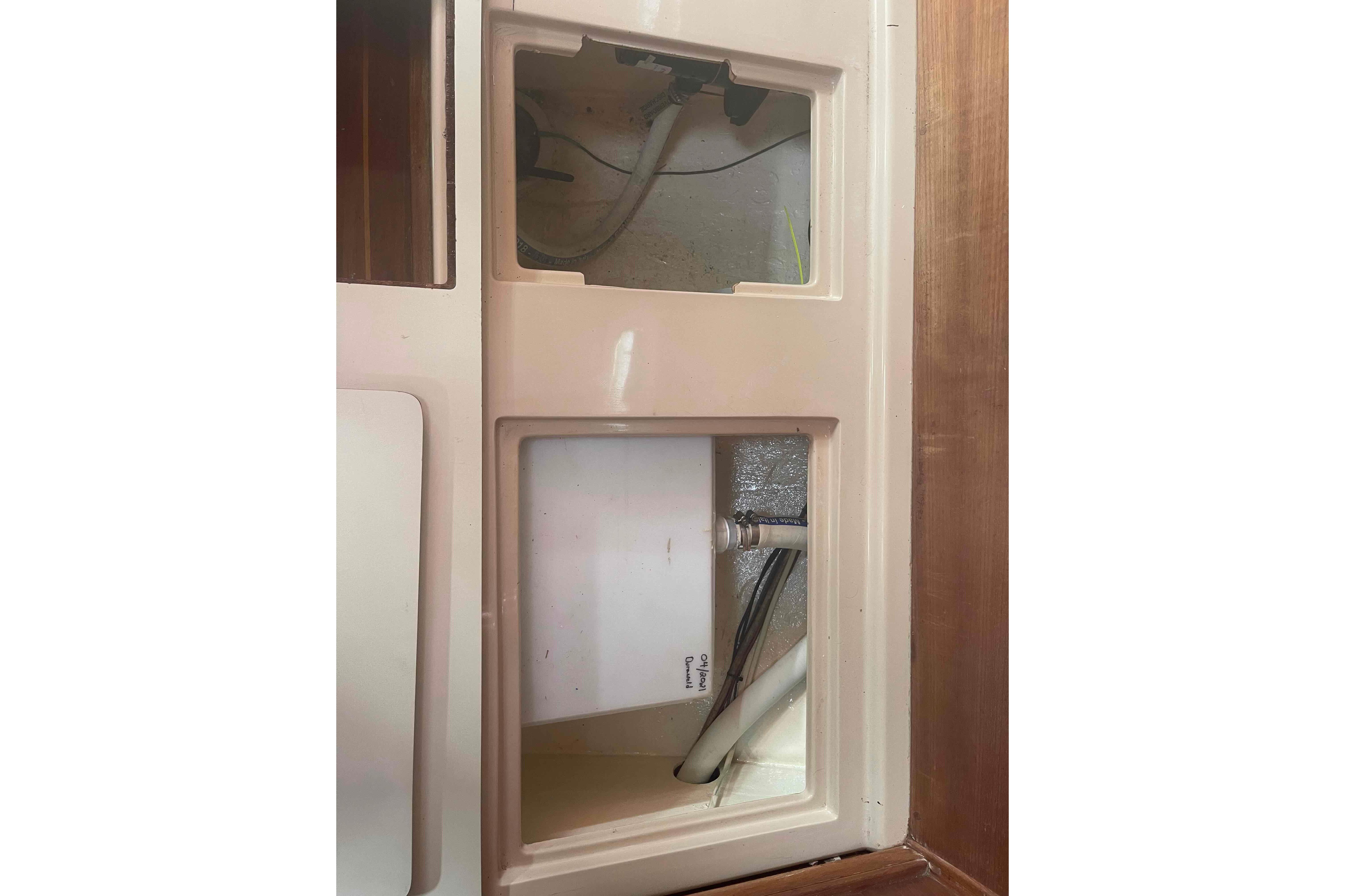 Interior compartment of 1989 Island Packet 35 sailboat, showing wiring and plumbing.
