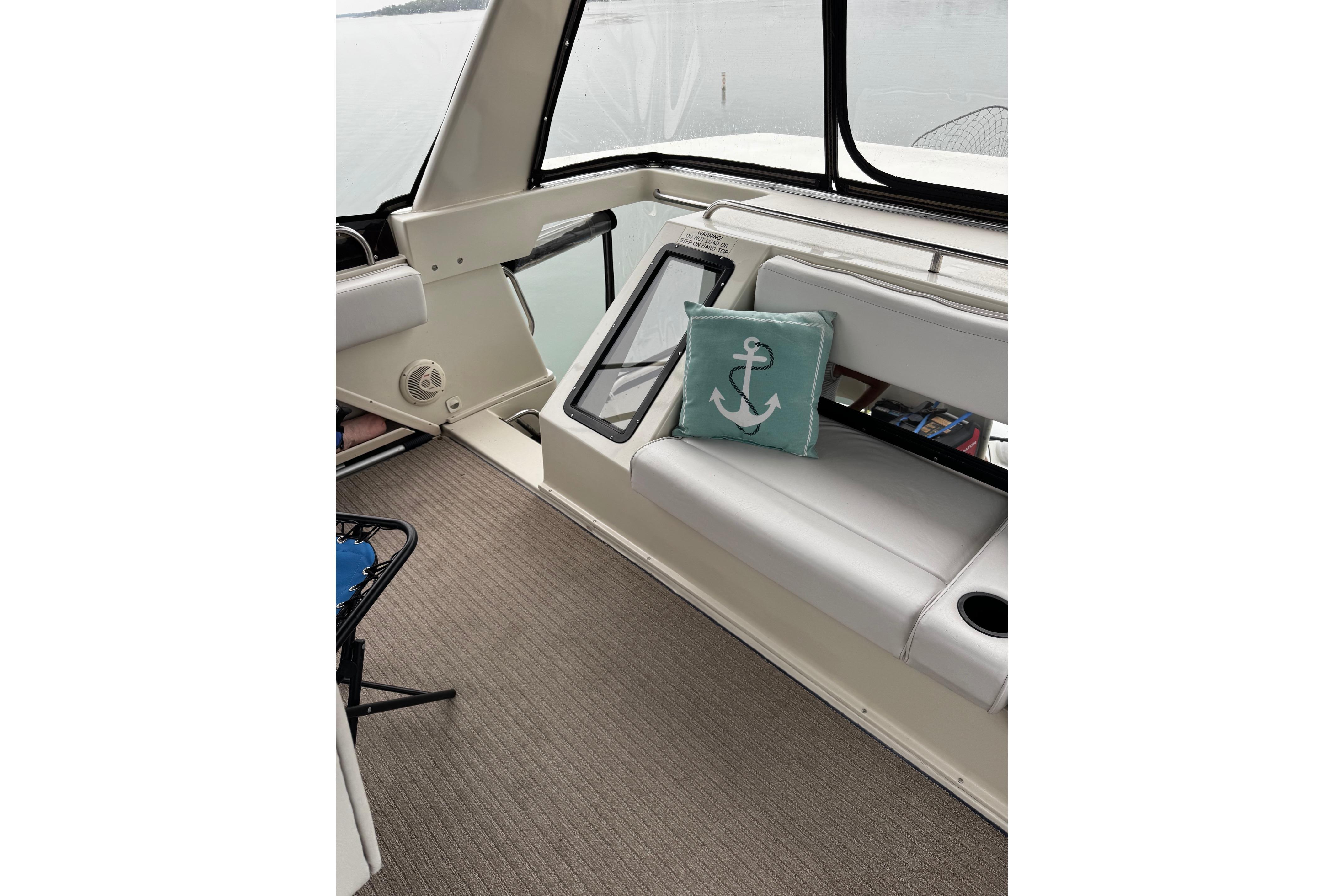 Interior of 1991 Silverton 46 Motor Yacht with anchor-themed cushion on white seating.