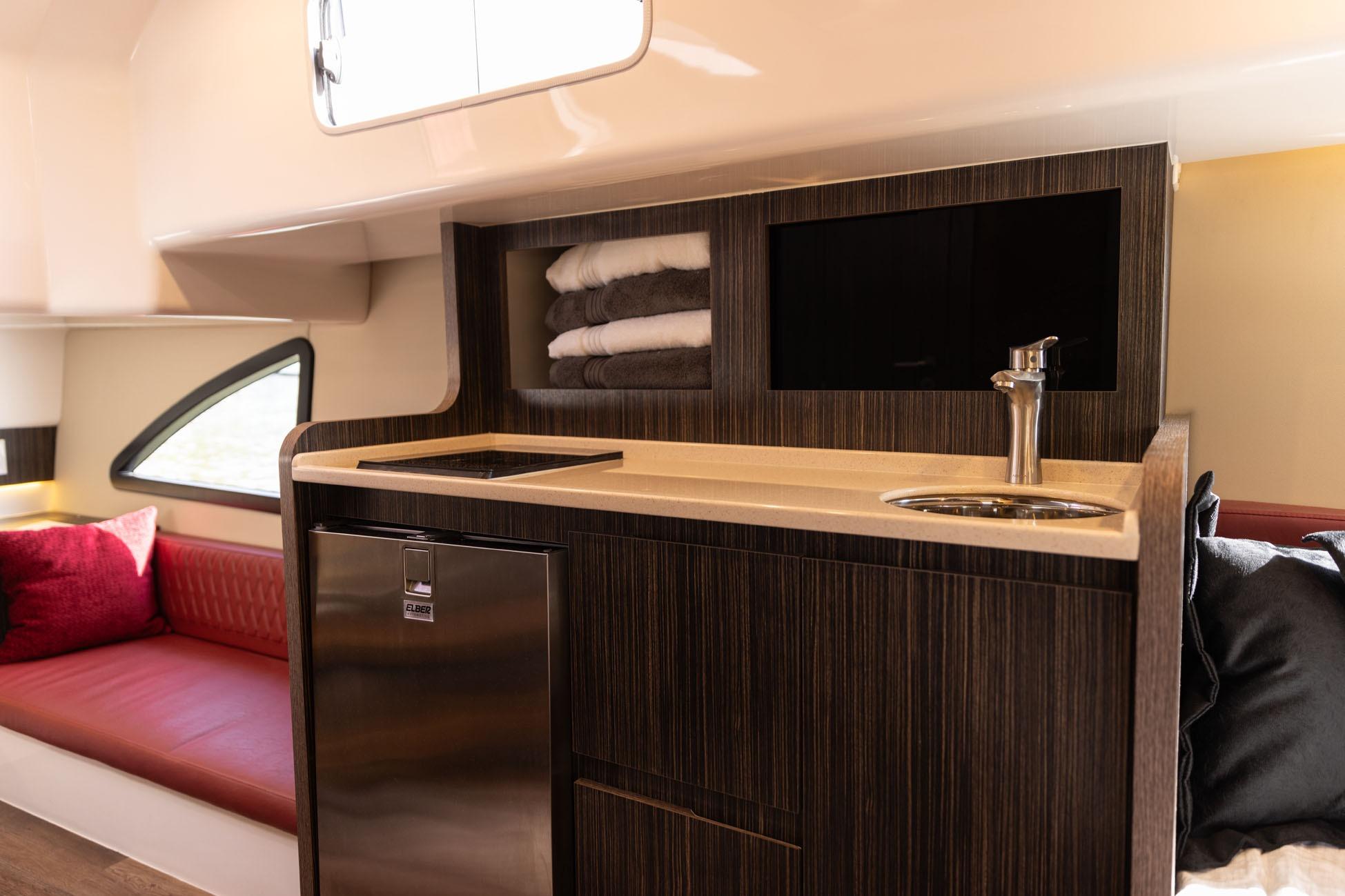 Luxurious interior of 2026 Hanover 387 yacht with kitchenette and seating area.
