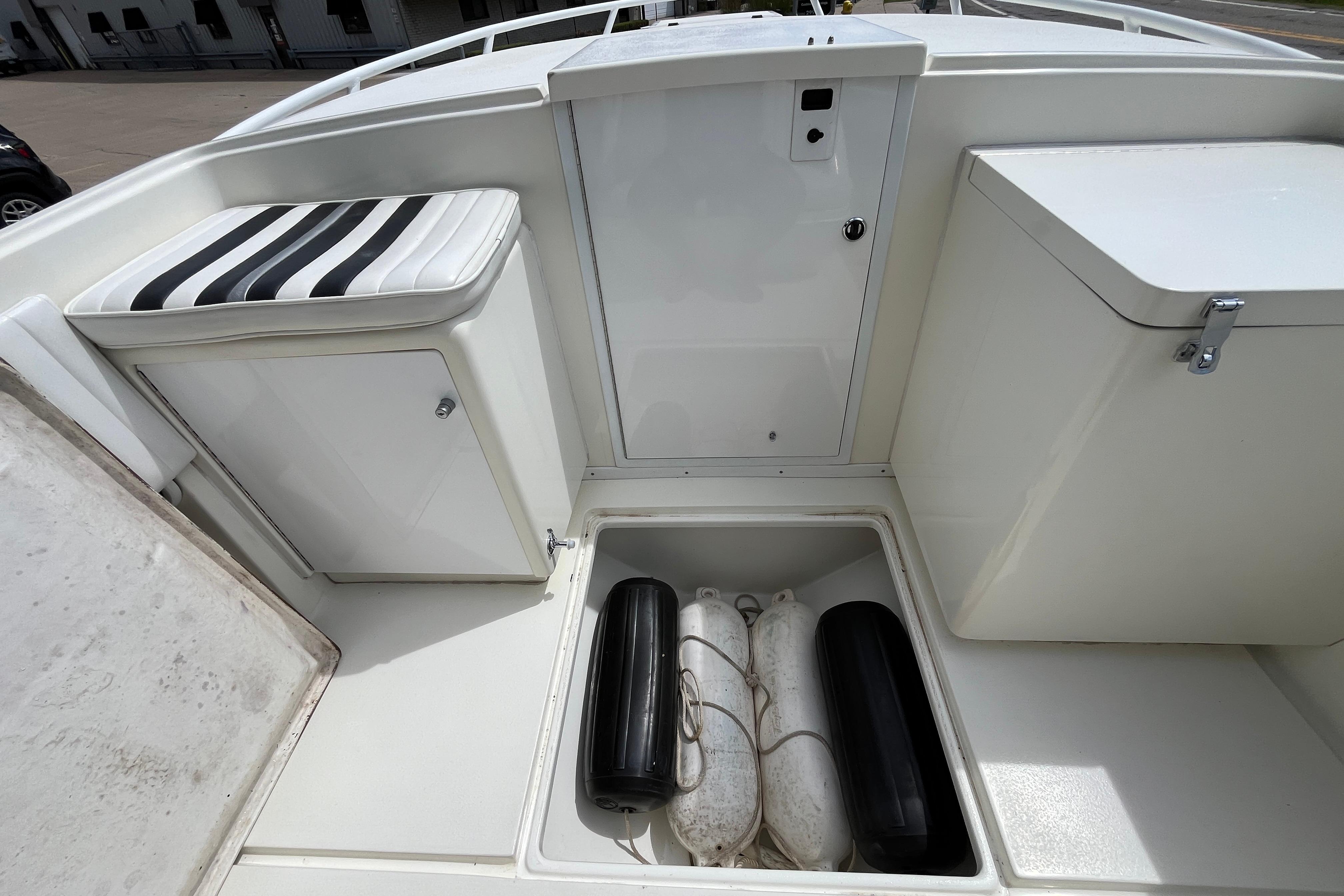 1994 Intrepid 30 Open Cuddy boat interior with storage compartments and striped seat cushion.