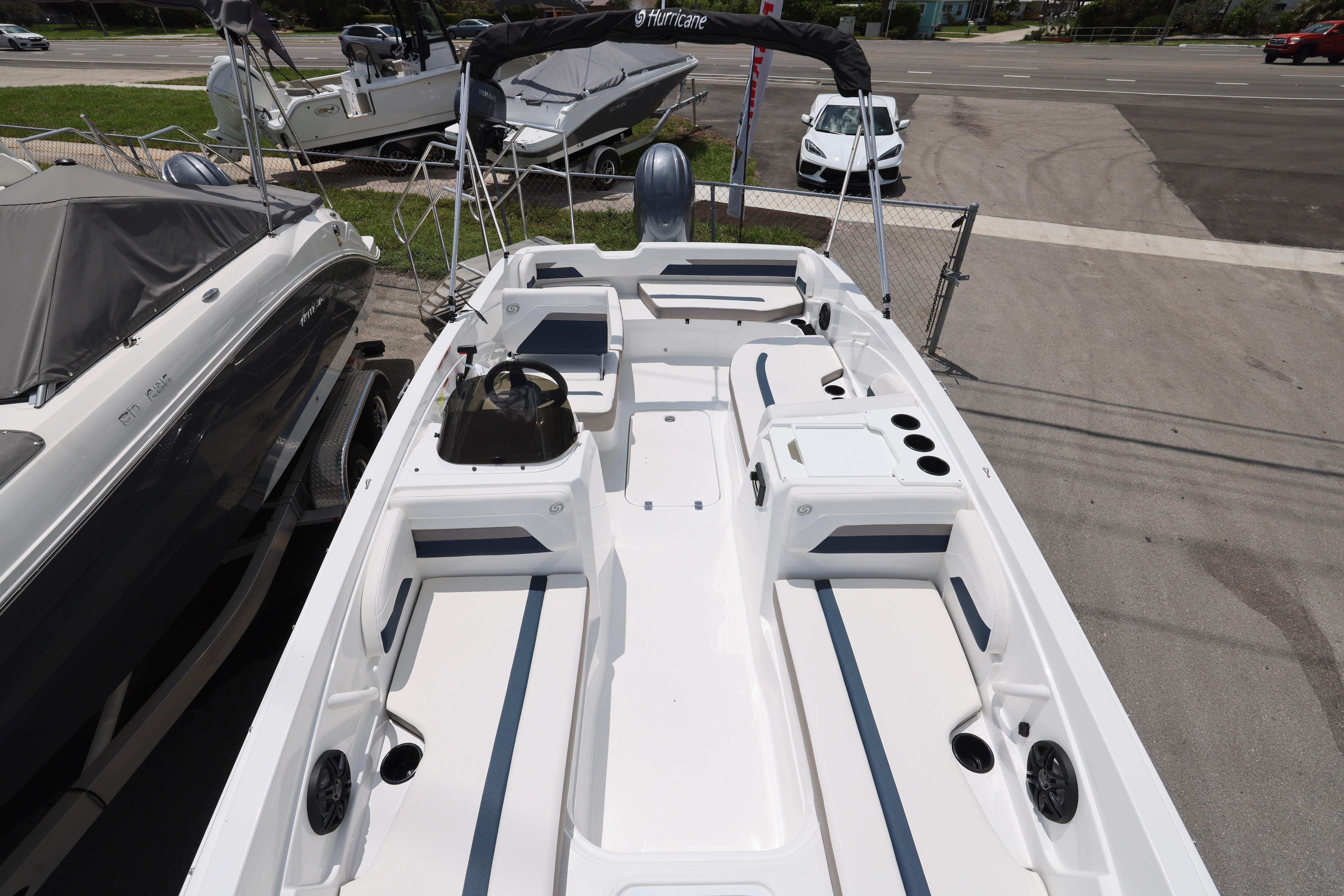 2026 Hurricane SunDeck Sport 205 OB boat, spacious seating, sleek design, parked outdoors.