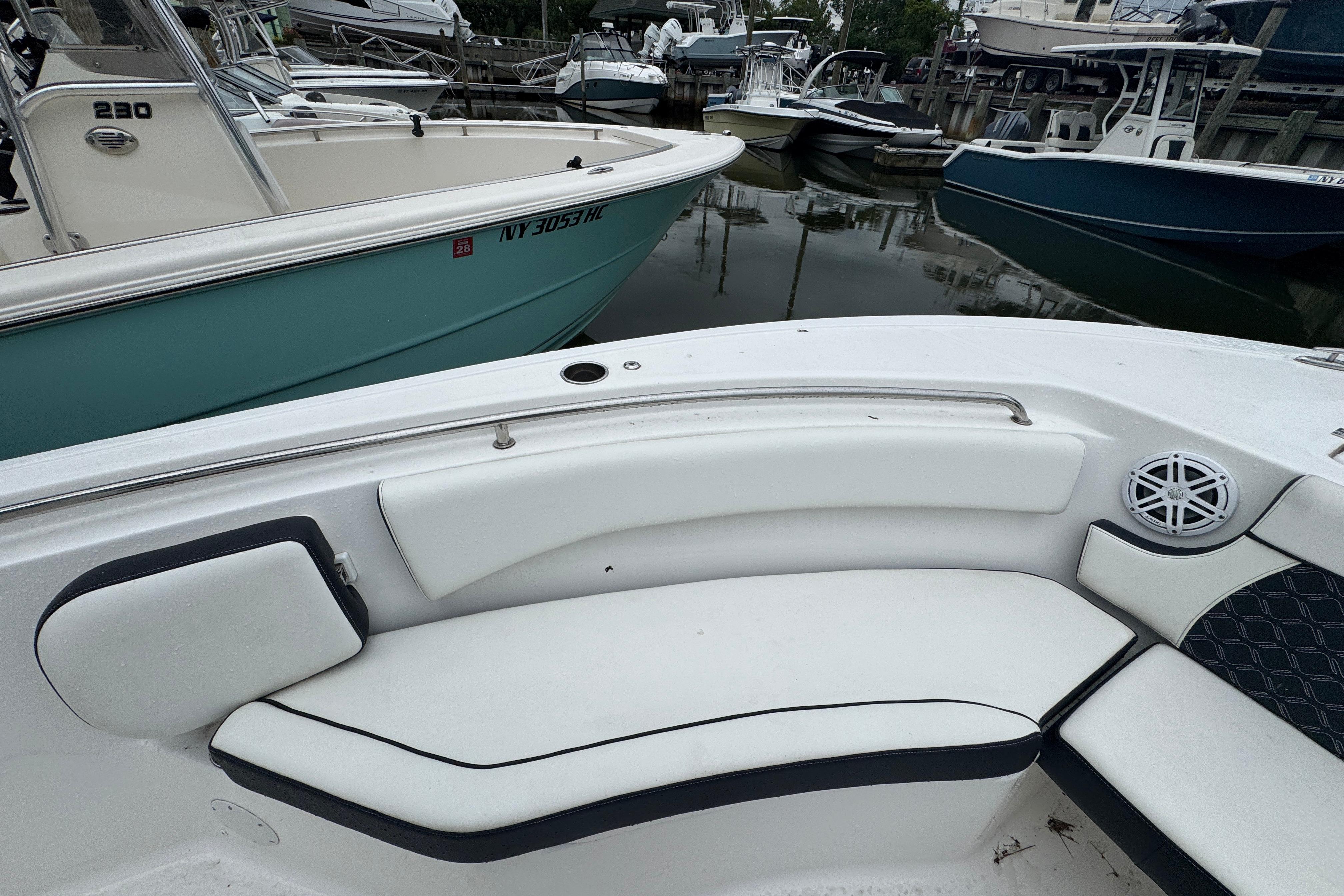 2022 Tidewater 232 SS boat interior with white seating, docked among other boats.